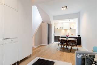 <p><span>Unieke charme, een hoogwaardige renovatie en een uitstekende ligging: deze karaktervolle stadswoning heeft het allemaal. Gelegen in een rustige, verkeersluwe straat woon je hier midden in de stad, met een school op 10m afstand en vlakbij winkels, horeca en openbaar vervoer. Ook de Ring en de stadsrand bereik je in een mum van tijd. De ideale uitvalsbasis voor wie het bruisende stadsleven wil combineren met rust en comfort.</span></p><p><span>De woning werd in 2021 volledig gerenoveerd met oog voor detail en afgewerkt met duurzame, kwalitatieve materialen. Daarbij werden onder meer de leidingen, elektriciteit, verwarming, vloeren, bezetting en de daken volledig vernieuwd. Voor zo veel mogelijk lichtinval werd er een skylight met hoogrendementsglas boven de keuken en tweede verdieping geplaatst. Daarnaast zijn de tussenvloeren geïsoleerd, werd de achtergevel in 2023 extra geïsoleerd en geniet je van een gunstige EPC-score B. Vooraan op het gelijkvloers zijn bovendien elektrische rolluiken voorzien en doorheen de woning is er ingebouwde Serax-verlichting aanwezig.</span></p><p><span>Via de stijlvolle inkomhal met elegante rasico-afwerking bereik je de gezellige leefruimte met open keuken van 47 m². De hoogwaardige afwerking met kalkbepleistering, eikfineer, graniet en microtopping zorgt voor een stijlvolle, warme en eigentijdse uitstraling. De open keuken is volledig uitgerust met kwalitatieve AEG-toestellen, Novy dampkap en een Quooker kraan. Op het gelijkvloers bevindt zich eveneens een apart gastentoilet.</span></p><p><span>De eerste verdieping omvat een ruime slaapkamer van 18 m² met een op maat gemaakte ingebouwde kast. Daarnaast bevindt zich de luxueuze badkamer van 11 m² met vrijstaand bad, inloopdouche, dubbele lavabo en toilet. De vloer-en muurafwerking in de badkamer is voorzien van microtopping. Op de bovenverdieping bevindt zich de royale masterbedroom van 35 m², die eenvoudig kan worden opgesplitst in twee volwaardige slaapkamers. Tot slot beschikt de woning nog over een praktische kelder van 30 m².</span></p><p><span>Ben je op zoek naar een instapklare stadswoning boordevol karakter, met een unieke afwerking en hedendaags wooncomfort? Mis deze kans niet! Voor meer info of een gratis schatting surf naar www.hansimmo.be</span></p><p><span> </span></p>