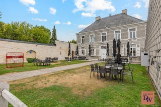 <strong>Een karaktervol en volledig gerenoveerd pand uit 2020, gelegen pal aan de kerk in het centrum van Burst.</strong> De voormalige pastorie combineert historische charme met hedendaags comfort en biedt een uitzonderlijke opportuniteit voor wie wonen en ondernemen wil combineren.<br />Op een prachtig perceel van maar liefst <strong>1.572 m²</strong> vinden we <strong>“De Pastorie”</strong>, een uniek gebouw met tal van mogelijkheden. Het pand kan aangekocht worden als <strong>instapklaar horecapand met ruime privéwoning</strong>, maar biedt dankzij zijn indeling en karakter eveneens interessante mogelijkheden als <strong>exclusieve privéwoning of kantoor met ruime parking</strong>.<br />Het gelijkvloers werd in <strong>2020 volledig gerenoveerd</strong> en ingericht als een stijlvolle horecazaak. De gezellige en ruime zaal biedt plaats aan ongeveer <strong>60 personen</strong> en beschikt over een sfeervolle bar.<br />Aansluitend bevindt zich een <strong>professionele keuken</strong>, waardoor het pand perfect geschikt is voor een restaurant, bistro of andere horecaconcepten. Een absolute troef zijn de <strong>twee zeer ruime terrassen</strong>, zowel aan de voor- als achterzijde van het gebouw. Zo kunnen uw gasten in alle rust genieten van een unieke, karaktervolle omgeving.<br />Op de eerste verdieping bevindt zich een ruime privéruimte met een ruime living, 4 slaapkamers, badkamer, allen zeer kwalitatief afgewerkt  en nu naar eigen smaak in te richten.<br />De zolderverdieping is bereikbaar via een vaste trap en biedt bovendien de mogelijkheid om, indien gewenst, bijkomende woonruimte te creëren.<br />Verder beschikt het pand over een <strong>kelder</strong>, een <strong>ruime garage</strong> en praktische <strong>bergruimtes</strong>.<br /><strong>Onmiddellijk beschikbaar.</strong><br />Bij aankoop als horecazaak wordt voor het <strong>handelsfonds, de goodwill en de aanwezige materialen</strong> een afzonderlijke overnameprijs gevraagd van <strong>€ 50.000</strong>.<br />Interesse?  Neem snel contact op via 0479/91 91 32 of mail naar wim@vastgoeddw.be <br /> 