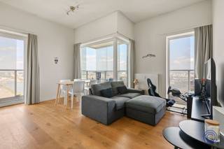 <p><span>Panoramisch wonen op de 18de verdieping aan het Eilandje</span></p><p><span>Op zoek naar een lichtrijk appartement met een uitzicht waar slechts weinigen van kunnen dromen? Op de 18de verdieping van een verzorgd appartementsgebouw aan de Ellermanstraat 61 bevindt zich dit aangename twee slaapkamerappartement met een indrukwekkend panoramisch zicht over de Antwerpse skyline en de dokken.</span></p><p><span>De lichtrijke leef- en eetruimte van ca. 32 m² wordt omringd door grote raampartijen en biedt voldoende plaats voor een comfortabele zit- en eethoek. Vanuit vrijwel elke hoek geniet u van het voortdurend veranderende uitzicht over Antwerpen. Aansluitend bevindt zich de volledig ingerichte open keuken, voorzien van een inductie kookplaat, dampkap, koelkast met diepvriesvak, microgolf en vaatwasser.</span></p><p><span>Het appartement beschikt over twee slaapkamers van respectievelijk ca. 12 m² en 9 m². De badkamer is uitgerust met een regendouche, lavabomeubel, spiegel en toilet. Daarnaast is er een extra, praktische berging met aansluitingen voor een wasmachine en droogkast.</span></p><p><span>Een absolute blikvanger is het royale terras dat zich rondom het appartement uitstrekt. Hier geniet u op verschillende momenten van de dag van de zon, de rust op hoogte en een uniek uitzicht over de stad en haar dokken.</span></p><p><span>Het appartement is volledig rolstoeltoegankelijk. Een privatieve parkeerplaats hoort bij het appartement en dient verplicht mee aangekocht te worden voor €30.000.</span></p><p><span> </span></p><p><span>Indeling</span></p><p><span>Lichtrijke leef- en eetruimte van ca. 32 m² met toegang tot het panoramisch terras van ca. 29m²</span></p><p><span>Volledig ingerichte open keuken voorzien van een inductie kookplaat, dampkap, koelkast met diepvriesvak, microgolf en vaatwasser.</span></p><p><span>Slaapkamer van ca. 12 m² op parketvloer met toegang tot het terras</span></p><p><span>Tweede slaapkamer van ca. 9 m² parketvloer met toegang tot het terras</span></p><p><span>Badkamer met inloop regendouche, lavabomeubel, spiegel en toilet</span></p><p><span>Extra berging met aansluitingen voor wasmachine en droogkast</span></p><p><span> </span></p><p><span>Belangrijkste troeven</span></p><ul><li><span>Gelegen op de 18de verdieping</span></li><li><span>Adembenemend uitzicht over Antwerpen en de dokken</span></li><li><span>Grote raampartijen en uitzonderlijk veel lichtinval</span></li><li><span>Royaal terras rondom het appartement</span></li><li><span>Twee slaapkamers</span></li><li><span>Volledig rolstoeltoegankelijk</span></li><li><span>Goed onderhouden gemeenschappelijke delen</span></li><li><span>Privatieve parkeerplaats verplicht mee aan te kopen</span></li></ul><p><span> </span></p><p><span>Algemene informatie</span></p><p><span>Elektriciteit met privatieve verbruiksmeter</span></p><ul><li><span>Elektrische installatie: conform</span></li><li><span>EPC: A-label </span></li><li><span>Asbestattest: niet van toepassing</span></li></ul><p><span> </span></p><p><span>Het gebouw</span></p><p><span>Het kwalitatieve en goed onderhouden appartementsgebouw omvat een ondergrondse verdieping met parkeerplaatsen en bergingen, een gelijkvloerse verdieping en 21 verdiepingen met appartementen. Het gebouw beschikt over meerdere liften en een videofoonsysteem.</span></p><p><span> </span></p><p><span>Ligging</span></p><p><span>Het appartement bevindt zich op een uitstekende locatie nabij de Antwerpse dokken en het bruisende Eilandje. Winkels, scholen, horeca en openbaar vervoer liggen op wandelafstand. Ook het historische stadscentrum en de Antwerpse Ring zijn vlot bereikbaar.</span></p><p><span>Een uitzonderlijke woonplek voor wie ruimte, licht, comfort en een spectaculair uitzicht over Antwerpen weet te waarderen.</span></p><p><span> </span></p><p><span>De informatie in deze prospect is ter informatieve titel: de kandidaat-kopers moeten hun eigen zaak maken van het verkrijgen, controleren en interpreteren van deze informatie.</span></p><p><span> </span></p>