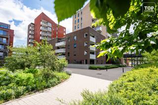 Dit prachtig appartement met parking ligt op de site van Dok Noord. Een toplocatie in Gent. <br /><br />Op de site zelf is alles aanwezig. Van een bakker tot supermarkt, tal van restaurants, cafeetjes en winkels... Heel wat ontspanningsmogelijkheden... Fitness, bowlen, poolen, karten, en tal van andere sporten. <br />Het appartement ligt omgeven door groen. Heel fijn om even te ontspannen. Tevens rijden er geen auto's op de site zelf waardoor het voor kinderen veilig spelen is. Dit zorgt voor een uniek locatie.<br /><br />Het historisch centrum van Gent is gemakkelijk te bereiken te voet en per fiets. Ook het station dampoort ligt op 5 min fietsen. <br />Enerzijds is alles dichtbij, anderzijds kan je genieten van de rust. <br />Kortom, met de ligging van dit appartement is een auto absoluut niet noodzakelijk.<br />Doch ben je in 5 min op de belangrijke toegangswegen de R4 en de E17. <br /><br />Via de inkomhal komen we terecht in de ruime leefruimte, met open keuken. Deze is volledig geïnstalleerd, er is zelfs een ingebouwde koffiemachine aanwezig. Het leefgedeelte is praktisch ingedeeld, zo kan de ruimte optimaal benut worden. Via het schuifraam kom je op het ruime terras, waar je lekker lang kan genieten met vrienden. Verder vinden we nog de badkamer met douche en bad, wc, bergruimte met aansluiting voor de wasmachine en 2 ruime slaapkamers terug. <br /><br />Extra troeven :<br />- Met zijn energie label A heeft het een gunstige EPC score<br />- Zowel de keuken als het hele appartement zijn hoogwaardig afgewerkt<br />- Het appartement werd opgeleverd in 2019 en is perfect onderhouden<br />- Het gebouw is voorzien van een eigen ondergrondse parking met aparte toegang<br />- Buiten een eigen ondergrondse parkeerplaats is er ook een gemeenschappelijke fietsenberging<br /><br />Je kan van dit gezellige appartement een echte thuis maken! Tevens kan het ook aanzien worden als opbrengsteigendom.<br /><br />Syndickosten zijn 120 Euro/maand<br /><br />Beschikbaar bij akte.<br /><br />Interesse in deze unieke opportuniteit? Contacteer dan Topvastgoed voor een bezoek op het nummer 0475 700 700.
