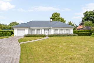 Deze eigendom is zeer verzorgd en is gelegen op een fraai aangelegd perceel. De woning is perfect geschikt voor levenslang wonen, met extra mogelijkheid tot uitbreiding op de bovenverdieping. <br /><br />Via de ruime inkomhal met apart toilet betreedt u de woning. De L-vormige leefruimte is lichtrijk door het gebruik van de vele ramenpartijen. <br />Aparte keuken voorzien van de nodige toestellen en ruimte voor het plaatsen van een extra eettafel. Aansluitend deze ruimte bevindt er zich een praktische bergruimte. De nachthal geeft toegang tot 2 ruime slaapkamers en praktische badkamer met hoekbad en dubbele lavabo. <br />In de woning is een inpandige garage voorzien. Deze geeft enerzijds toegang naar de achtertuin en anderzijds de mogelijkheid met een vlizotrap de zolder te betreden. Deze kan nog afgewerkt worden tot extra leefruimte.<br /><br />De tuin is zeer verzorgd, volledig omheind en voorzien van een elektrische toegangspoort. Op het vernieuwde ruime terras is het zalig vertoeven. Alsook is er een ruim tuinhuis aanwezig, ideaal voor het opbergen van tuinmateriaal.<br /><br />Bijzonderheden:<br />- Goed onderhouden eigendom op centrale locatie <br />- Aanwezigheid van 10 zonnepanelen<br />- Recente warmtepompboiler van 270l + verwarmingsketel<br />- Geboorde waterput aangesloten op zowel de buitenkant als de binnenkant van de woning<br />- Vernieuwde badkamer + vloeren<br />- Rolluiken
