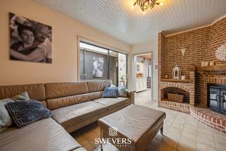 Voor meer info en foto’s, surf naar www.swevers.be – In Kwaadmechelen vind je deze gesloten bebouwing met een verrassend ruime indeling en tal van mogelijkheden voor wie op zoek is naar een comfortabele gezinswoning. De woning werd gebouwd in 1952 en beschikt over een bewoonbare oppervlakte van circa 239 m² op een perceel van 431 m². Binnenin geniet je van een praktische structuur met meerdere leefruimtes en vier slaapkamers.<br />Via de inkomhal bereik je op het gelijkvloers een aparte bureauruimte, ideaal als thuiswerkplek. Verder kom je in een ruime woonkamer die aansluit op een tweede zithoek, waardoor verschillende indelingen mogelijk zijn. Centraal ligt de keuken van 14,94 m², met aansluitend een wasruimte, badkamer en apart toilet. Daarnaast zijn er nog een werkplaats, berging en een ruime garage van 28,49 m².<br />Op de eerste verdieping bevinden zich twee ruime slaapkamers van 22,27 m² en 14,02 m². De tweede verdieping telt nog twee extra kamers van 13,60 m² en 11,87 m², ideaal als kinder-, logeer- of hobbykamer. Extra bergruimte vind je in de kelder van 11,56 m².<br />De zuidgerichte tuin zorgt voor veel zon en biedt mogelijkheden om een aangename buitenruimte te creëren. De ligging is bovendien erg praktisch: winkels op 500 meter, scholen en restaurants op ongeveer 1 km, openbaar vervoer op 15 meter en de snelweg op slechts 3 km. Een interessante woning met veel ruimte en potentieel voor gezinnen. Voor meer informatie, bel 011 255 155. Bron bewoonbare oppervlakte: EPC – verslag.