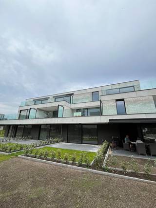 Bent u op zoek naar een energiezuinig nieuwbouwappartement op een rustige locatie? Dan is dit stijlvolle appartement op de eerste verdieping in Zandhoven zeker een bezoek waard.<br /><br />Het appartement, met een bruto vloeroppervlakte van 80,87m², beschikt over een lichtrijke leefruimte met open keuken die uitgeeft op een ruim westgericht terras van 24 m².<br /><br />De moderne keuken is volledig uitgerust met kwalitatieve AEG-toestellen, waaronder een inductiekookplaat, dampkap en vaatwasser. Daarnaast is er een combi-oven en koelkast met vriesvak voorzien.<br /><br />Verder omvat het appartement:<br />- inkomhal<br />- ruime leefruimte<br />- 2 slaapkamers<br />- badkamer met inloopdouche en lavabo<br />- apart gastentoilet<br />- praktische berging<br /><br />Het appartement wordt bovendien volledig geschilderd opgeleverd. Ook worden er gordijnrails geplaatst en wordt de nodige verlichting voorzien, zodat u het appartement instapklaar kunt betrekken. Het appartement zal beschikbaar zijn vanaf 15/08/2026.<br /><br />Voor extra comfort beschikt het gebouw over een lift. Bovendien zijn een ondergrondse autostaanplaats en een privatieve kelderberging inbegrepen in de huurprijs.<br /><br />Dankzij de warmtepomp, zonnepanelen en het ventilatiesysteem geniet u van een bijzonder energiezuinige woonst. Elke woonentiteit beschikt over een eigen elektriciteitsmeter en er is de mogelijkheid om een laadpaal te voorzien voor een elektrische wagen.<br /><br />Troeven<br />- lift aanwezig<br />- mogelijkheid tot laadpaal<br />- gemeenschappelijke fietsenstalling<br /><br /><br />Gemeenschappelijke kosten: € 65/maand<br />*EPB in aanmaak<br />*3m HWB<br />*Plaatsbeschrijving