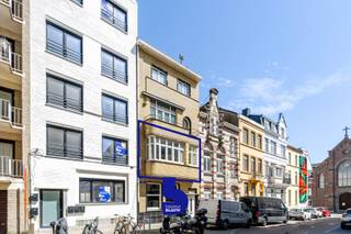 Dit uitzonderlijk ruime woonappartement bevindt zich op de eerste verdieping van een stijlvolle residentie in het bruisende hart van Oostende. Achter de gevel schuilt een appartement waarin architecturale verfijning en hedendaags comfort elkaar ontmoeten, met een duidelijke knipoog naar de elegantie van de Art Deco-stijl. Geometrie, ritme en een doordachte indeling zorgen voor een harmonieus geheel dat rust en karakter uitstraalt.<br /><br />Bij het betreden van het appartement wordt u meteen ondergedompeld in een gevoel van ruimte en licht. Hoge plafonds en een vloeiende overgang tussen de leefruimtes creëren een open en luchtige sfeer. De royale woonkamer vormt het centrale leefpunt en wordt verrijkt door een karaktervolle open haard die als een subtiel sculpturaal element de ruimte definieert. Grote raampartijen laten het daglicht rijkelijk binnenstromen en versterken de connectie met de stad.<br /><br />De keuken is afzonderlijk opgevat en biedt een functionele, centrale plek binnen het appartement. <br /><br />Het appartement beschikt over twee volwaardige slaapkamers, elk met hun eigen beleving van rust en privacy. De bijkomende bureauruimte biedt flexibiliteit en kan perfect dienen als thuiskantoor, creatieve ruimte, dressing of derde slaapkamer.<br />De badkamer werd ingericht met oog voor eenvoud en comfort, waarbij zachte materialen en een ingetogen afwerking bijdragen aan een serene sfeer.<br /><br />Een bijkomende troef is de mogelijkheid tot het creëren van een tweede ruim terras, waardoor een beschutte buitenruimte kan ontstaan die het wooncomfort nog versterkt en een subtiele verbinding legt tussen binnen en buiten.<br /><br />Gelegen op wandelafstand van het strand en de zee, en omringd door het levendige stadsleven van Oostende, biedt dit appartement een zeldzame combinatie van ligging, ruimte en architecturale uitstraling. Dit is geen standaardwoning, maar een plek waar esthetiek en woonkwaliteit samenkomen in een tijdloos geheel, ontworpen om in alle rust te beleven.