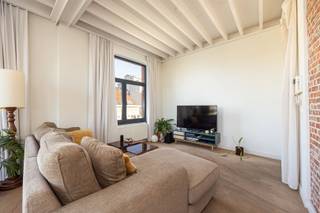 <p>Aan de Cuylitsstraat 119 woon je niet zomaar op het Zuid, maar erboven. Op de derde verdieping van een karaktervol, kleinschalig gebouw wacht een appartement waar architectuur, licht en uitzicht de hoofdrol spelen. Met het iconische Vlinderpaleis recht voor je raam en het Zuid als dagelijkse habitat.</p><p>Hier maken vooral de volumes het verschil. De witgeschilderde balkenstructuur, hoge plafonds, grote boogramen en accenten in zichtbare baksteen geven het appartement zijn eigen architecturale karakter. Dankzij de vele raampartijen valt het daglicht van verschillende kanten binnen en wordt Antwerpen haast onderdeel van het interieur.</p><p>• Toplocatie op het Antwerpse Zuid<br />• Derde verdieping met weids stadszicht<br />• Frontaal zicht op het iconische Vlinderpaleis<br />• Bijzondere architectuur met hoge plafonds en balkenstructuur<br />• Lift<br />• Kleinschalig gebouw</p><p>De leefruimte is open, ruim en allesbehalve doorsnee. Wonen, tafelen en koken vloeien in elkaar over, terwijl de ramen het uitzicht voortdurend naar binnen trekken. De strakke maatkeuken met groot natuurstenen kookeiland vormt het centrale punt: veel werkruimte, veel bergruimte en minstens even geschikt voor een snel ontbijt als voor een lange avond met vrienden.</p><p>De slaapkamer volgt dezelfde architecturale lijn, met royale raampartijen, hoge plafonds en voldoende ruimte voor een uitgebreide dressing. Verder zijn er een badkamer met inloopdouche en een praktische, afzonderlijke wasberging.</p><p>En buiten? Zuidpark, KMSKA, Scheldekaaien, M HKA, restaurants, koffiebars en galeries liggen allemaal op wandelafstand. Hier koop je dus niet alleen een appartement, maar vooral een plek midden in een van de leukste stukken Antwerpen.</p><p>New York heeft zijn skyline. Hier krijg je Antwerpen gewoon ingekaderd vanuit je woonkamer.</p><p>Benieuwd of het uitzicht in het echt nog beter is? Plan je bezoek via Sinjoor of bel 03 283 05 00.</p>
