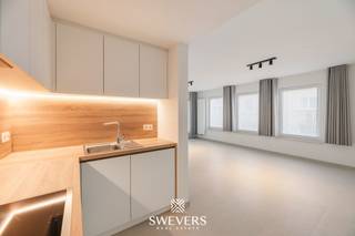 Voor meer info en foto’s, surf naar www.swevers.be – Op een uitstekende locatie aan de Oude Kuringerbaan 12 bus 2 in Hasselt bevindt zich dit volledig gerenoveerde appartement met twee slaapkamers. Het appartement ligt op de eerste verdieping van een residentie uit 1999 en beschikt over een bewoonbare oppervlakte van 76 m². Dankzij de grondige renovatie in 2026 is het volledig instapklaar, met nieuwe vloeren, een moderne keuken met toestellen, een vernieuwde badkamer en toilet en frisse schilderwerken. De lichtrijke leefruimte van 30,48 m² biedt voldoende plaats voor een gezellige zit- en eethoek en sluit aan op de open keuken van 5,67 m². Vanuit de leefruimte bereik je het overdekte balkon. Verder zijn er twee slaapkamers van 11,70 m² en 9,16 m², een badkamer met inloopdouche en dubbele lavabo, een apart toilet en een praktische berging. Het overdekte balkon vormt een aangename extra buitenruimte. Ook op vlak van comfort scoort dit appartement uitstekend. Het is energiezuinig, beschikt over conforme elektriciteit en is asbestveilig. Bovendien zijn een lift, videofoon, parlofoon en raamdecoratie aanwezig. De rustige ligging op amper 500 meter van het centrum van Hasselt is een grote troef. Winkels, restaurants, scholen en openbaar vervoer bevinden zich op korte afstand. Ook de snelwegen zijn vlot bereikbaar. Een ideale keuze voor wie op zoek is naar een modern, instapklaar appartement met twee slaapkamers op wandelafstand van het stadscentrum. Voor meer informatie, bel 011 255 155. Bron bewoonbare oppervlakte: EPC – verslag.