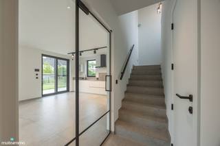 <span>HOOGWAARDIG AFGEWERKTE NIEUWBOUWWONING MET DRIE SLAAPKAMERS EN TUIN (INCLUSIEF TUINONDERHOUD) TE RIEMST</span><br /><br />Deze nieuwbouwwoning vinden we terug aan Int Boelarvelt 15 te Zichen-Zussen-Bolder, een deelgemeente van Riemst. Dankzij de ligging in een doodlopende straat geniet de woning van veel rust en beperkte verkeersdrukte. Alle nodige faciliteiten zijn in de nabije omgeving gelegen, net zoals het op- en afrittencomplex van de autostrade waardoor omliggende dorpen en steden vlot bereikbaar zijn.<br /><br />De woning is afgewerkt met hoogwaardige materialen en is voorzien van alle comfort, zo zijn er 10 zonnepanelen, een regenwaterput van 5000 liter waarop de toiletten en de buitenkraan zijn aangesloten, een alarminstallatie, 1 laadpaal, verlichting en een warmtepomp.<br /><br />De indeling van de woning is als volgt:<br />GELIJKVLOERSE VERDIEPING:<br />- Inkomhal.<br /><br />VERDIEPING -1:<br />- Lichtrijke woonkamer met open keuken. De keuken is voorzien van een inbouwkoelkast, inductiekookplaat met afzuigkap, oven, microgolfoven en een vaatwasser.<br />- Ruime berging met aansluiting voor het wasmachine.<br />- Toilet.<br /><br />VERDIEPING +1:<br />- Nachthal.<br />- 3 slaapkamers.<br />- Badkamer. De badkamer is voorzien van een dubbele lavabo en een inloopdouche.<br /> - Toilet.<br /><br />De woning is voorzien van twee parkeerplaatsen en een ruime omheinde tuin met terras en een buitenberging.<br /><br />De huurprijs bedraagt € 1.375,00 + € 225,00 vaste kosten per maand.<br />In de vaste maandelijkse kosten zitten volgende zaken inbegrepen: onderhoud warmtepomp, onderhoud regenwatersysteem + vervangen van de filters, onderhoud ventilatie + vervangen van de filters, onderhoud buiten (snoeien haag en perken, verwijderen grof onkruid, gebruik robotmaaier inclusief het onderhoud van de robotmaaier).<br /><br /><span>Wilt u graag een bezichtiging inplannen voor deze prachtige nieuwbouwwoning? Contacteer ons dan vrijblijvend via info@matisimmo.be.</span>