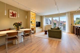 <strong>Voor meer informatie of een bezoek bel Annabel: 0474 17 27 13</strong><br /><br />Dit prachtig afgewerkte appartement combineert een warme, hedendaagse inrichting met hoogwaardige materialen en een uitzonderlijke ligging in het stadscentrum. Gelegen in een rustige straat, geniet u hier van een aangename woonomgeving terwijl het bruisende stadsleven zich op wandelafstand bevindt.<br /><br /><strong>Indeling</strong><br />Via de stijlvolle inkomhal met vestiaire en gastentoilet komt u terecht in de lichtrijke leefruimte, waar een warme en uitnodigende sfeer meteen opvalt. De gezellige zithoek en ruime eetplaats vloeien harmonieus in elkaar over. De parketvloer en de verfijnde afwerking geven de leefruimte een stijlvolle uitstraling, waarbij elk detail bijdraagt aan het luxueuze karakter van het appartement.<br /><br />De open keuken sluit naadloos aan op de leefruimte en is een echte blikvanger. Ze werd uitgevoerd in warme houttinten en beschikt over kwalitatieve, geïntegreerde toestellen. Het ruime kookeiland met zitgelegenheid maakt de keuken niet alleen praktisch, maar zorgt ook voor een gezellige plek waar u graag tijd doorbrengt.<br /><br />Vanuit de leefruimte heeft u rechtstreeks toegang tot het zuidgerichte terras, waar u volop kan genieten van de zon. De ideale plek om heerlijk te ontspannen of op een zonnige dag gezellig te barbecueën met vrienden en familie.<br /><br />Het appartement beschikt over twee ruime slaapkamers, beide voorzien van maatkasten die perfect aansluiten bij het interieur. Ook de twee badkamers zijn met oog voor detail afgewerkt en hebben een moderne, elegante uitstraling. De verlichte spiegels zorgen voor een verfijnde afwerking en dragen bij aan het stijlvolle karakter van de ruimtes.<br /><br />Daarnaast beschikt het appartement over een geïntegreerde bureauruimte, waar het zorgvuldig uitgewerkte maatwerk en de subtiele verlichting zorgen voor een aangename plek om in alle rust thuis te werken.<br /><br /><strong>Ligging en omgeving</strong><br />De ligging is zonder twijfel een van de grootste troeven van dit appartement. Verscholen in een rustige straat, midden in het historische centrum van Gent, geniet u hier van een uitzonderlijke combinatie van rust en stadsleven. Zodra u de deur uitstapt, ontdekt u alles wat deze bruisende stad te bieden heeft.<br /><br />Gezellige koffiebarretjes, verfijnde restaurants, lokale boetieks en tal van winkels bevinden zich op wandelafstand. Ook de Korenmarkt, de Kouter en de sfeervolle winkelstraten liggen vlakbij. Of u nu houdt van een uitgebreid ontbijt in de stad, een namiddag shoppen of een avondje uit, hier ligt alles binnen handbereik.<br /><br /><strong>Bereikbaarheid</strong><br />Dankzij de centrale ligging verplaatst u zich moeiteloos te voet of met de fiets doorheen Gent. Ook het openbaar vervoer is vlot bereikbaar, met verschillende tram- en busverbindingen in de nabije omgeving. <br /><br />Voor wie graag over een eigen parkeerplaats beschikt, bestaat bovendien de mogelijkheid om een autostaanplaats aan te kopen voor € 50.000. Een bijzonder praktische troef op deze centrale locatie.<br /><br />Dit appartement is de ideale thuisbasis voor wie op zoek is naar een verfijnde woonervaring op een van de meest gegeerde locaties van Gent. Hier geniet u van het beste van twee werelden: de rust van een aangename woonstraat en de levendigheid van de stad vlakbij.<br /><br />Energiezuinig: EPC 89 kWh/(m2jaar), energielabel A<br />Bruto bruikbare vloeroppervlakte volgens EPC verslag 11m2<br />Stedenbouwkundige inlichtingen: woongebied met cultureel, historische en/of esthetische waarde, voorkooprecht, vergunningen, geen verkavelingsverguning, geen rechterlijke herstelmaatregel of bestuurlijke maatregel opgelegd. <br />Het perceel te Gent, afdeling 15, sectie F met perceelnummer 1003/00W002 bevindt zich niet in een risicozone voor overstromingen. <br /><br /><strong>Benieuwd naar dit bijzondere appartement? Contacteer Annabel via telefoon: 0474 17 27 13 of via mail: annabel@ocvastgoed.be</strong>
