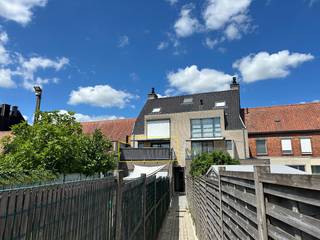 Centraal gelegen appartement op de 1e verdieping, met uitweg en garage achteraan in de Vlasstraat.<br /><br />Inkomhal, gastentoilet, badkamer, open keuken, leefruimte, berging en groot terras.<br />De twee slaapkamers zijn voorzien van rolluiken.<br />Het terras paalt aan de living en is bereikbaar via het schuifraam.<br />Er is een zonneluifel voorzien boven het schuifraam.<br /><br />Aluminium schrijnwerk en centrale verwarming op aardgas.<br /><br />Toegang tot het gebouw zowel van op de Rijksweg als vanuit de Vlasstraat.<br />De bijhorende garage heeft een kantelpoort en een achterdeur.<br /><br />Het appartement is momenteel verhuurd. Interessant voor zowel starters als voor investeerders.