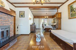 Voor meer info en foto’s, surf naar www.swevers.be – Deze halfopen woning in de Onze-Lieve-Vrouwstraat 69 in Heusden-Zolder biedt veel ruimte, licht en potentieel op een mooi groen perceel van 1.680 m². De woning dateert van 1953, werd steeds goed onderhouden en beschikt over een bewoonbare oppervlakte van 192m². Binnenkomen doet u via de inkomhal met trap. U betreed vervolgens de eerste ruime leefruimte, gevolgd door de centraal gelegen keuken van 12 m² , die vernieuwd werd in de jaren 2000. Deze sluit dan weer aan op een tweede leefruimte die perfect dienst kan doen als veranda of ontbijthoek en dankzij de grote raampartij geniet van veel licht en een mooi zicht op de tuin. Achteraan bevinden zich de vernieuwde badkamer met inloopdouche en een aparte wasplaats/berging. Op de eerste verdieping zijn er drie ruime slaapkamers van 16 m², 18 m² en 16 m². Eén kamer is ingericht als kleine studio met slaapruimte, dressing, compacte kitchenette en leefhoek. Verder is er nog een apart toilet. Via een vaste trap bereikt u de zolder van ca. 40 m², die tal van mogelijkheden biedt voor extra kamers of hobbyruimte. Ook is er een kelder van 7 m² en een vrijstaand bijgebouw. De tuin is een grote troef, met achteraan veel ruimte voor een moestuin, dieren of ontspanning in alle privacy. Winkels, scholen en ontspanning liggen dichtbij, openbaar vervoer op 200 meter en de snelweg op 1 km. Voor meer informatie, bel 011 255 155. Bron bewoonbare oppervlakte: EPC – verslag.