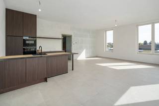 Deze ruime penthouse op de derde verdieping in Eilandpark, Sint-Lievens-Houtem is doordacht ingedeeld en afgewerkt met hoogwaardige materialen. Dankzij de royale glaspartijen geniet u van overvloedig natuurlijk licht en een lichte, elegante en bijzonder comfortabele woonbeleving.<br /><br />Met een bruto oppervlakte van 120 m² beschikt de penthouse over twee slaapkamers en een ruime leefruimte die naadloos aansluit op het 21 m² grote zuidgerichte terras. Dankzij de ideale oriëntatie geniet je hier de hele dag door van zon, in combinatie met een prachtig open zicht op het bos. Het appartement zelf kijkt eveneens rechtstreeks uit op het groen, waardoor een uniek gevoel van rust en natuur gecreëerd wordt.<br /><br />De woning is bijna energieneutraal en combineert duurzame technieken met een verfijnde afwerking. Je wagen parkeer je veilig in de ondergrondse garage, vanwaar de lift je rechtstreeks tot aan de penthouse brengt. De autoluwe opzet van de site versterkt het rustige karakter van deze groene woonomgeving.