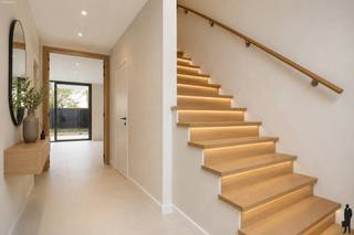 Deze hedendaagse nieuwbouwwoning combineert <strong>moderne architectuur </strong>met een praktische en doordachte indeling. Dankzij de grote raampartijen en de open leefruimtes geniet de woning van veel natuurlijke lichtinval en een aangenaam ruimtegevoel. De woning werd ontworpen met oog voor comfort, <strong>energiezuinigheid</strong> en <strong>kwalitatieve materialen</strong>, waardoor ze perfect aansluit bij hedendaags wooncomfort.<br /><br />
<p><strong>Gelijkvloers<br /></strong>- Indrukwekkende inkomhal met dubbele <strong>hoogte van ca. 5,7 m</strong> en grote raampartij<br />- Massieve eiken trap <br />- Sas met <strong>gastentoilet</strong> en technische ruimte/berging<br />- Toegang tot de geïntegreerde<strong> garage</strong><br />- Lichtrijke woonkamer van ca. 30 m² met veel raampartijen <br />- Schuifraam met toegang tot het achterliggende terras<br />- Patio aan de zijkant waar genoten kan worden van de avondzon<br />- Open keuken met eetplaats van ca. 24 m² en eveneens een schuifraam naar het terras<br />- Plafondhoogte van ca. 2,8 m op het volledige gelijkvloers, met ramen uitgewerkt tot dezelfde hoogte voor extra ruimte- en lichtgevoel</p>
<p><strong>1e verdieping<br /></strong>- Nachthal <br />- 3 ruime slaapkamers (24, 20 en 18 m²) <br />- Masterbedroom met eigen inloopdouche <br />- Centrale badkamer afgewerkt met <strong>natuursteen,</strong> voorzien van inloopdouche, vrijstaand bad en dubbele lavabo<br />- Apart toilet</p>
<p><strong>Tuin en buitenruimte</strong></p>
<p>- Terras aansluitend aan de leefruimte en keuken<br />- Ommuurde patio tuin die zorgt voor extra privacy <br /><br /><b>Troeven<br /></b>- <strong>Kwalitatieve </strong>materialen: aluminium buitenschrijnwerk, natuursteen en massieve eik<br />- Vloerverwarming in combinatie met <strong>warmtepomp</strong><br />- Zonnepanelen <br />- Terrassen, tuinafsluiting en grondwerken reeds uitgevoerd<br />- Zeer energiezuinige woning<br />- <strong>Mogelijkheid tot aankoop aan 6% btw </strong><br />- Keuken nog vrij te kiezen en te plaatsen naar eigen smaak<br /><br />Een stijlvolle en energiezuinige nieuwbouwwoning waar ruimte, licht en comfort centraal staan. Contacteer ons voor meer informatie of een bezichtiging.</p>
