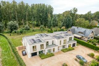 Gelegen aan de Gentsesteenweg te Erondegem (Erpe-Mere) woon je hier bijzonder rustig én bijzonder vlot bereikbaar. De kleinschalige residentie 't Hemelsveld is zowel vooraan als achteraan omgeven door natuurgebied. Alle dagelijkse voorzieningen liggen in de onmiddellijke omgeving: bakker, slager, apotheek, grootwarenhuis, tankstation en horeca. De bushalte bevindt zich op 100m en de oprit van de E40 op 3 km.<br /><br />Deze moderne halfopen bebouwing van 20m diep en 7m breed telt ongeveer 236 m² woonoppervlakte op een perceel van circa 6a84ca, met een zuidgerichte tuin. De woning werd gebouwd volgens de strengste normen inzake isolatie en ventilatie, en dat laat zich voelen: overvloedig licht, een uitgesproken ruimtegevoel en een opvallend akoestisch comfort dankzij de driedubbele beglazing.<br /><br />Op het gelijkvloers brengt de zij-inkom je in een zeer ruime leefruimte van 70m². De open keuken sluit aan op een praktische berging. Verder vind je hier een slaapkamer (of thuisbureau) met eigen badkamer, een apart gastentoilet en een inpandige garage. Het aansluitende terras is voorzien van een buitendouche en de aansluitingen voor een buitenkeuken, ideaal om in de zomermaanden volop buiten te leven.<br /><br />De verdieping telt drie bijkomende slaapkamers, een ruime badkamer, een apart toilet en een extra ruimte die zich uitstekend leent als dressing of bureau. Het hoogtepunt is de rechtstreekse toegang tot het zonneterras op de verdieping, met zicht op de tuin en het bos.<br />Voor de woning bevinden zich er nog 3 autostaanplaatsen.<br /><br />Technisch is deze woning uitzonderlijk doordacht. De combinatie van passiefbouw en zonnepanelen zorgt voor een aanzienlijk lager energieverbruik. Een regenwaterput van 10.000 liter met bijhorend zuiveringssysteem levert bijzonder zacht water, wat het verbruik van leidingwater sterk terugdringt. De driedubbele beglazing is zonwerend uitgevoerd.<br /><br />Troeven:<br />Zuidgerichte tuin van 25 m diep met meerdere terrassen<br />Ruime leefruimte van 70 m² met veel lichtinval<br />Driedubbele zonwerende beglazing <br />Regenwaterput van 10.000 l met zuiveringssysteem<br /><br />Bestuursmaatregelen in het maatregelenregister: nee
