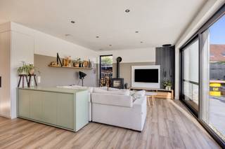 Deze mooie, ruime en lichtrijke woning (2023) bevindt zich op een grond van ruim 18 are. <br /><br />Dit pand omvat een woongedeelte: gelijkvloers: inkomhal, woonkamer met leefkeuken (65 m²), slaapkamer met bijhorende dressing, badkamer (wastafel, inloopdouche, ligbad), toilet en technische ruimte; verdieping: nachthal, vide (speelhoek), 2 zeer ruime slaapkamers en toilet; werkgedeelte (eveneens in te richten als extra woon- en/of slaapruimte): polyvalente ruimte (45 m²) met open keuken, badkamer, berging, archief en toilet.<br /><br />Buiten bevinden zich een ruime oprit voor meerdere wagens, 2 grote terrassen, een omheinde en volledig aangelegde tuin met zeer grote tuinberging. Achterliggend: agrarisch gebied.<br /><br />Deze energiezuinige woning met EPC-label A is volledig geïsoleerd, uitgerust met zonnepanelen, warmtepomp en airconditioning. De elektrische installatie is volledig conform. Er zijn geen asbestmaterialen aanwezig. Niet gelegen in overstromingsgevoelig gebied.<br /><br />Ideaal voor wie graag ruim en modern woont en van thuis uit wil werken, in alle rust met zicht op een groene omgeving en voor wie houdt van een kwalitatieve afwerking.