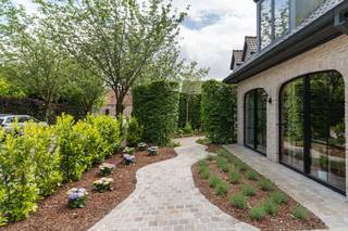 Deze uitzonderlijk ruime woning in het gegeerde De Pinte biedt maar liefst 309 m² bewoonbare oppervlakte op een perceel van 913 m². Dankzij de doordachte indeling, de royale woonoppervlakte en de aparte kantoor- en studiovleugel vormt deze eigendom de ideale combinatie van comfortabel wonen, werken aan huis en veelzijdige gebruiksmogelijkheden waaronder woon-werk maar ook co-housing/kangeroewonen.<br />De woning beschikt over een een praktische was- en bergruimte en een afzonderlijk gastentoilet. Verder leidt het gelijkvloers u naar de ruime leefkeuken, die het kloppende hart van het huis vormt en naadloos aansluit op de lichtrijke leefruimte. Grote raampartijen zorgen voor een aangename lichtinval en creëren een directe verbinding met de verzorgde, onderhoudsvriendelijke tuin. De gezellige zithoek en tv-ruimte maken het geheel bijzonder uitnodigend voor het hele gezin.<br /><br />Een grote troef van deze woning is de aanwezigheid van twee volwaardige slaapkamers en een badkamer op het gelijkvloers. Dit biedt niet alleen extra comfort, maar maakt de woning ook toekomstbestendig en geschikt voor wie gelijkvloers wil wonen.<br /><br />Op de eerste verdieping bevinden zich nog drie ruime slaapkamers, waarvan één momenteel is ingericht als dressing. Daarnaast zijn er twee extra badkamers en verschillende praktische bergruimtes aanwezig. Met in totaal vijf slaapkamers en vier badkamers biedt deze woning uitzonderlijk veel ruimte voor grote gezinnen, samengestelde gezinnen.<br /><br />Aansluitend aan de woning bevindt zich een volledig nieuwe kantoorruimte, met aparte inkomhal, ideaal voor vrije beroepen, zelfstandigen of wie professioneel van thuis uit werkt. Boven deze kantoorruimte bevindt zich een volledig ingerichte studio met eigen keuken en badkamer, wat tal van mogelijkheden biedt.<br /><br />De combinatie van een royale woonoppervlakte, een praktische indeling, meerdere badkamers, een aparte professionele ruimte en een uitstekende ligging in het centrum van De Pinte maakt van deze eigendom een unieke opportuniteit voor wie op zoek is naar ruimte, flexibiliteit en wooncomfort.<br /><br /><strong>Bovenvermelde prijs betreft een richtprijs.</strong>