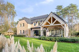 Deze prachtig afgewerkte villa bevindt zich op een bijzonder rustige en residentiële locatie in een jonge doodlopende verkaveling, omringd door groen. Je woont hier in alle privacy en comfort, met tegelijk een vlotte verbinding naar Mol, Balen, omliggende gehuchten en lokale winkels.<br /><br />Via de inkomhal, met gastentoilet en ingebouwde vestiaireruimte, kom je zowel in de woonkamer als in de leefkeuken. De woonkamer geniet dankzij de grote ramen van veel natuurlijke lichtinval en heeft een mooi zicht op de groene tuin. De leefkeuken bestaat uit een kwalitatieve aanbouwkeuken die voorzien is van alle comfort, met granieten werkbladen, een Amerikaanse koelkast, diepvries, heteluchtoven, microgolfoven, stoomoven, inductiekookplaat met teppanyakiplaat en geïntegreerde afzuigkap, een vaatwasser (allen Miele) en veel kastruimte. De eethoek grenst aan het overdekte terras. Doordat de keuken tot in de nok is opengetrokken, geniet je hier van een aangenaam ruimtegevoel. De authentieke eiken balken zorgen voor karakter en gezelligheid. In de woning is tevens een Sonos-installatie geïntegreerd, wat zorgt voor een warme sfeer en een heel aangename beleving in het dagelijkse wooncomfort.<br /><br />Op de verdieping zijn er drie ruime slaapkamers, waarvan er twee beschikken over een eigen dressing en een aansluitende badkamer. De badkamer van de masterbedroom is uitgerust met een ligbad, douche, dubbele wastafel en toilet. De andere badkamer omvat een douche, enkelvoudige wastafel en toilet. Op deze verdieping bevindt zich ook de linnenkamer, voorzien van inbouwkasten en een handige uitgietbak. Een luik met uitschuiftrap geeft toegang tot de zolderverdieping, die perfect dienstdoet als extra stockageruimte en waar je, indien gewenst, nog een extra (slaap)kamer kan creëren.<br /><br />In de tuin bevindt zich een prachtig overdekt en deels afgesloten terras waar je geniet tot de laatste avondzon. Verder is er een beregeningsinstallatie, een maairobot, sfeervolle buitenverlichting en een houten tuinhuis. Wanneer de woning wordt gekocht op enkel het linker perceel, dient het tuinhuis te worden afgebroken omdat het zich midden op de perceelsgrens bevindt.<br /><br />Het rechter perceel (30m breed x 40m diep) is tevens een bouwgrond en zit bij in de prijs begrepen!<br /><br />De woning is volledig voorzien van vloerverwarming en vloerkoeling via een warmtepomp met diepteboring. De voorzieningen voor airco zijn voorbereid en weggewerkt, maar bleken voor de huidige eigenaars niet nodig. Een balansventilatiesysteem type D met bypass zorgt voortdurend voor verse, gefilterde lucht. <br /><br />De villa beschikt over een zeer ruime garage voor twee wagens, met extra opbergruimte. De grote dubbele deur maakt het makkelijk om ook grotere stukken binnen te brengen. Een deel van de technieken is hier ondergebracht, zoals de omvormer van de 41 zonnepanelen, de thuisbatterij van 29,5 kWh en de centrale van het alarmsysteem. Een deel van de woning is onderkelderd, de rest heeft een kruipkelder.<br /><br />Ben je op zoek naar een ruim ingedeelde en kwalitatief afgewerkte villa op een mooi perceel in een rustige groene omgeving? Dan is deze woning ongetwijfeld een bezoekje waard.