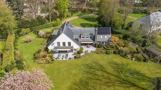 Deze villa is niet alleen aan en zeer mooie en brede laan gelegen, bovendien is de villa zelf erg ruim opgezet (uitbreiding mogelijk: zeer royale bouwzone!) én gelegen op een uniek en perfect zuid georiënteerd perceel aan de rand van de wijk Vriesdonk. <br />Energetisch reeds voorzien van zonnepanelen en thuisbatterijen! <br /><br />Deze villa van ca. 640 m² bewoonbare oppervlakte staat centraal ingeplant op de grond van ca. 5.463 m² én geniet van een mooie tuin voorzien van statige oude bomen welke alle nodige privacy biedt., welke men na een kronkelende lange oprijlaan bereikt.<br /><br />Het perceel heeft aan de D'Oultremontlei een straatbreedte van ca. 29 meter met brede inrit naar de villa met aansluitende gebogen lange privé oprit naar parkeerterrein en dubbele garage. De straatzijde aan de kant van de Frilinglei bedraagt ruim 61 meter!<br /><br />Hoewel de villa nu reeds alle ruimte en comfort biedt (oa EPC B), zou deze, volgens de voorschriften kunnen worden uitgebreid tot ca. 1.200 m² woonoppervlakte (mits akkoord omgevingsvergunning).<br /><br /><strong>Indeling:</strong><br />Riante entree met ruime vestiairekasten en gastentoilet; via glazen deuren doorzicht naar achtertuin en ruime tussenhal met bureel. <br />Voorts dubbele schuifdeuren naar zonnige L-vormige living bestaande uit een zitgedeelte (43m²) met open haard en eetkamer (36m²); voorzien van aluminium schuiframen en panoramaraam met uitzicht op de achtertuin met ruim terras.<br /><br />Dubbele inpandige garage met sectionaal poorten en achterliggende werkplaats met personeelsingang.<br /><br /><strong>Verdieping:</strong><br />In totaal zijn er zes kamers, twee volwaardige badkamers en een douchekamer met toilet.<br />De mastersuite of ouderslaapkamer heeft een oppervlakte van ca. 35m², ingemaakte kasten, balkon en ensuite badkamer. Nog twee slaapkamers welke een badkamer delen, en nog eens twee slaapkamers met tussenliggende douchekamer met toilet. Ruime fitnesskamer c.q. kantoor aan huis (45,5m²) met ingemaakte kastenwand.<br /><br /><strong>Kelder:</strong><br />De villa heeft een grote kruipruimte en 3-tal kelders: wijn- en bergkelder en een technische ruimte met stookolie e/o gas CV. <br />Er is een gas Vaillant HR-ketel geplaatst (nov 2024). Hierdoor heeft men de mogelijkheid om te switchen tussen verwarming op stookolie of verwarming op gas (beiden aanwezig). Elektrische warmtewisselaar/boiler. Tevens zitten hier de omvormer van de PV installatie (12 zonnepanelen) alsook de dubbele thuisbatterij in een aparte ruimte.<br /><br /><strong>Tuin en buitenruimtes:</strong><br />Grenzend aan living en keuken zijn er twee ruime zuidgerichte terrassen op blauw steen met elektrische zonneschermen. In de achtertuin geniet u van veel privacy en bevindt zich een ruime saunablokhut.<br /><br />De unieke ligging en het ruime perceel bieden de mogelijkheid tot renoveren/uitbreiden van de huidige villa. Huidig geldende voorschriften geven mogelijkheden tot een riant huis. Het verkrijgen van dit grote volume is natuurlijk altijd onder de opschortende voorwaarde van het bekomen van de omgevingsvergunning. <br /><br />Algemeen: renovaties in 2005 en 2013 en 2024.