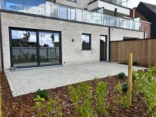 Volledig afgewerkt en instapklaar appartement met ruim terras en privatief tuintje.<br />Oplevering bij akte.<br /><br />Indeling: er is een inkomhal die toegang geeft tot twee slaapkamers, badkamer, toilet en keuken. Via de open keuken heb je overigens toegang tot een aparte berging, de lichtrijke leefruimte, ruim terras en tuin. De badkamer bestaat uit een inloopdouche en een dubbele lavabo.<br /><br />De bewoonbare oppervlakte bedraagt 107,00 m². De oppervlakte van het terras bedraagt 29 m².<br /><br />Langs de doorgang naar achter bevinden zich de bergingen. Achteraan zijn de garageboxen met een oppervlakte van 18m², voorzien van manuele sectionale poort. Kan geautomatiseerd worden, voorzieningen voor het plaatsen van een laadpaal zijn ingewerkt.<br /><br />De prijs van de berging bedraagt 6.300,- euro. <br /><br />E-peil 30 (50% vrijstelling op onroerende voorheffing voor 5 jaar) in basis zijn 4 zonnepanelen (435 Wp/st) inbegrepen. Uitbreiding pv installatie is mogelijk zodat E-peil 10 gehaald wordt met volledige vrijstelling van onroerende voorheffing voor 5 jaar.<br /><br />Warmtepomp (lucht/water) met vloerverwarming met apart regelbare circuits per ruimte.<br /><br />Alle bedragen zijn exclusief garages, bergingen en alle kosten. Bijhorende berging nr. 6 dient mee aangekocht te worden. Er zijn nog 4 vrije garages, er kan één of meerdere mee aangekocht worden.<br /><br />Prijs voor het appartement met garage en berging is 385.065,- euro (exclusief registratie, btw, notaris en aansluitingskosten) Opsplitsing als volgt: grondaandeel 80.850,- euro, constructiewaarde 304.215,- euro.<br /><br />AANKOOP AAN 6% BTW OP CONSTRUCTIE MOGELIJK: zowel voor eigen bewoning als bij engagement tot lange verhuur (minstens 15 jaar)