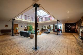 Ontdek deze gerenoveerde voormalige textielfabriek (industriële charmante loft met terras, oprit en parking, en groot atelier), gelegen in het centrum van Ronse. <br />Dit unieke pand combineert karakter en moderne luxe, met tal van mogelijkheden voor zowel professioneel als privégebruik.<br /><br />De loft, gerenoveerd in 2020, biedt een luxueus woongedeelte met een nieuw dak, (2 plateaus van +-200m² waarvan één in mezzanine), gebruikmakend van stijlvolle en kwalitatief hoogstaande materialen zonder hierbij de charmes van het authentieke gebouw aan te tasten (open ruimte met mezzanine, ingerichte keuken, moderne badkamer, slaapgelegenheid, sauna). Overdekt terras met jacuzzi. <br />Atelier/polyvalente ruimte: ontvangstruimte, groot atelier, een professionele keuken met koelcel en een ruime sanitaire blok met aparte dames- en herentoiletten. <br />Handige grote parking (tevens bouwgrond). <br /><br />Een uitzonderlijke kans voor wie op zoek is naar een uniek, veelzijdig pand met eindeloze mogelijkheden.