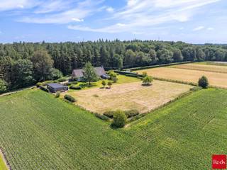 <p>Op zoek naar een exclusieve villa op een unieke toplocatie in het groen? Neem dan zeker contact op met nathan@reds.be <br /><br />Midden in het prachtige natuurgebied "De Hulsten", langs de historische Voort, bevindt zich deze uitzonderlijke eigendom waar luxe, ruimte en rust naadloos samenkomen. Op een domein van ruim 7.200 m² geniet u dagelijks van een adembenemend uitzicht over uitgestrekte velden en bossen, met een ongeziene privacy en natuurbeleving.</p>
<p>Met een bewoonbare oppervlakte van circa 500 m² biedt deze villa indrukwekkende volumes en een hoogwaardige afwerking. Grote raampartijen brengen het omliggende landschap volledig tot zijn recht en creëren een unieke woonervaring waarbij binnen en buiten in elkaar overvloeien. De royale leefruimte van ongeveer 100 m² met vide, authentieke trekspantconstructie en sfeervolle haard vormt samen met de open leefkeuken het kloppende hart van de woning.</p>
<p>De woning beschikt onder meer over een luxueuze master suite met dressing, badkamer en infraroodsauna, meerdere slaapkamers en badkamers, een fitnessruimte en een afzonderlijk gedeelte dat perfect geschikt is als kantoor, praktijkruimte, zorgwoning of kangoeroewoning.</p>
<p>Ook buiten werd niets aan het toeval overgelaten. De prachtig aangelegde tuin biedt maximale privacy en beschikt over ruime terrassen, een jacuzzi en paardenstallen met aparte toegang.</p>
<p>Dankzij de unieke ligging langs een autovrije, geklasseerde Romeinse heirbaan geniet u hier van absolute rust, terwijl comfort, veiligheid en moderne technieken overal aanwezig zijn.<br /><br />Bovendien is kangoeroe-wonen hier ook mogelijk.<br /><br /></p>
<p>Een zeldzame eigendom voor wie op zoek is naar een exclusieve woonbeleving op een van de mooiste locaties van Zandhoven.</p>