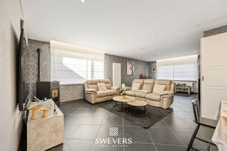 Voor meer info en foto’s, surf naar www.swevers.be – Deze instapklare open bebouwing aan de Klein Tegelrijstraat 72 in Nieuwerkerken werd gebouwd in 1964 en onderging in 2018 een zeer grondige en doordachte totaalrenovatie. Hierbij werd bewust ingezet op kwaliteit, comfort en een optimale woonbeleving, met aandacht voor zowel de praktische indeling als de hedendaagse woonbehoeften. Met 100 m² bewoonbare oppervlakte en een perceel van 750 m² combineert de woning comfortabel wonen met interessant uitbreidingspotentieel. Op het gelijkvloers bevinden zich een inkomhal met gerestaureerde originele trap, een leefruimte van 28 m² met pelletkachel en een ruime keuken van 24 m². Verder zijn er een wasplaats, berging en apart toilet. De veranda vormt een lichtrijke extra leefruimte en sluit aan op het terras met pergola en de oostelijk georiënteerde tuin. De eerste verdieping telt twee ruime slaapkamers van elk circa 16 m², een badkamer met inloopdouche, dubbele lavabo en toilet, een berging en overloop. De zolder van circa 50 m² biedt extra mogelijkheden om bijkomende woonruimte te creëren. Ook de aangebouwde garage van 40 m² zorgt voor heel wat parkeer- en bergruimte. Extra troeven zijn de zonnepanelen, thuisbatterij, airco’s die koelen en verwarmen en rolluiken. Bovendien bestaat de mogelijkheid om op termijn een slaapkamer en badkamer op het gelijkvloers te voorzien. Rustig gelegen met openbaar vervoer, scholen, horeca en winkels vlot bereikbaar. Ook het provinciedomein Nieuwenhoven en diverse fiets- en wandelroutes liggen in de omgeving. Voor meer informatie, bel 011 255 155. Bron bewoonbare oppervlakte: EPC – verslag.