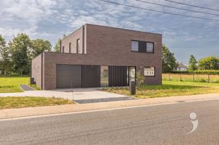 <p><span>Ruime en energiezuinige nieuwbouwwoning op een perceel van 20 are</span></p><p><span>Deze moderne nieuwbouwwoning combineert een doordachte indeling, grote leefruimte en een energiezuinige afwerking. Gelegen op een perceel van 20 are geniet u hier van rust, ruimte en een vlotte bereikbaarheid.</span></p><p><span>Via de inkomhal met gastentoilet en wastafel bereikt u een praktische bureauruimte, die eveneens kan worden ingericht als vijfde slaapkamer. De lichtrijke leefruimte omvat een ruime zithoek en eetplaats, met grote raampartijen die zorgen voor een aangenaam contact met de tuin. Aansluitend bevindt zich de open keuken, volledig uitgerust en voorzien van alle hedendaags comfort. Verder beschikt het gelijkvloers over een praktische berging met aansluiting voor wasmachine en droogkast, extra opbergmogelijkheden, een wastafel en een achterdeur naar de tuin. Verder is er ook een inpandige garage.</span></p><p><span>Op de eerste verdieping bevinden zich vier volwaardige slaapkamers, afgewerkt met een parketvloer. De master bedroom beschikt over een ensuite badkamer met douche, dubbele wastafel en een toilet. Daarnaast is er een tweede badkamer uitgerust met een ligbad, een ruime inloopdouche met regendouche en een dubbele wastafel. Op de nachthal bevinden zich nog een apart toilet en een praktische technische berging.</span></p><p><span>Buiten geniet u van een volledig aangelegde, zuidgerichte tuin met terras. Er is bovendien voldoende ruimte voor het plaatsen van een tuinhuis. De ruime oprit biedt plaats aan meerdere voertuigen en is voorbereid voor de installatie van een laadpaal.</span></p><p><span>De woning werd gebouwd met aandacht voor comfort en energiezuinigheid en is uitgerust met zonnepanelen, ventilatiesysteem type D en vloerverwarming die zowel kan verwarmen als passief koelen.</span></p><p><span>Interesse in deze ruime nieuwbouwwoning? Contacteer ons via 016 15 31 15 of info@immolivit.be voor meer informatie of een bezoek.</span></p>