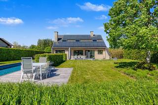 Deze zeer verzorgde alleenstaande woning in Pajottegem combineert ruimte, comfort en een uitzonderlijke panoramisch zicht op velden en bossen voor én achter de woning. Dankzij de zonnige oriëntatie geniet je hier de hele dag van licht en rust in de mooi aangelegde tuin met zwembad en ruime terrassen.
Op het gelijkvloers beschikt de woning over een inkomhal met gastentoilet, een lichtrijke woonkamer, ingerichte keuken met aanpalende berging en toegang tot de garage, evenals een ruim thuiskantoor dat perfect kan dienen als extra slaapkamer of praktijkruimte. De verdieping omvat een open nachthal, 4 slaapkamers (waarvan 3 met maatkasten) en een recent vernieuwde badkamer met ligbad, inloopdouche en dubbele wastafel.
Extra troeven zijn de fotovoltaïsche zonnepanelen met hoge opbrengst, gunstige EPC-score, de laadpaal, asbestveilig attest, comforme elektriciteit, regenwaterput en de volledig instapklare afwerking.
Rustig en landelijk gelegen, op wandelafstand van station, bushaltes, scholen en winkels, met vlotte verbindingen naar Brussel, Halle en Geraardsbergen.Voor meer info of bezoek contacteer Sophie 0496/71.50.59