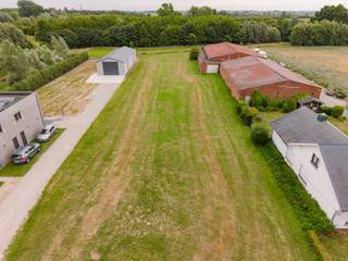 Unieke bouwgrond van 2.690 m² – Gentstraat 14, Zilverberg (Roeselare)<br /><br />Bent u op zoek naar een ruim perceel waar wonen en ondernemen gecombineerd kunnen worden? Dan biedt deze uitzonderlijke bouwgrond een zeldzame opportuniteit.<br /><br />Met een oppervlakte van 2.690 m², een straatbreedte van meer dan 24 meter en een diepte van ca. 112 meter biedt dit perceel tal van mogelijkheden. Achteraan grenst het aan bosgebied, wat zorgt voor een blijvend groen uitzicht, maximale privacy en de zekerheid dat er achteraan niet meer gebouwd wordt.<br /><br />Gelegen aansluitend op de dorpskern van Zilverberg en op slechts 1 km van het centrum van Roeselare, met een uitstekende bereikbaarheid via de N32, N36 en E403. Winkels, scholen, openbaar vervoer en andere voorzieningen bevinden zich in de directe omgeving.<br /><br />De bestemming laat onder meer toe:<br />• vrijstaande woning;<br />• woning met administratieve bedrijfszetel;<br />• woning met para-agrarische activiteit (o.a. dierenarts, trimsalon, logopedist, psycholoog, labo, landschapsarchitect...);<br />• woning met achterliggende loods of hangaar;<br />• vrijstaande loods of hangaar, ook zonder woning.<br /><br />Dankzij de royale perceeloppervlakte kan een ruime loods of hangaar worden gebouwd voor opslag, werkplaats, stalling, dierenhouderij of commerciële, ambachtelijke en industriële activiteiten. De bedrijvigheid hoeft niet grondgebonden te zijn.<br /><br />Geschikt voor onder meer een garagebedrijf, grondwerker, tuinaanlegger, machineherstel, hondenpension, veehandel of andere ondernemingen.<br /><br />Troeven<br />✔ 2.690 m² bouwgrond<br />✔ Straatbreedte > 24 m – diepte ±112 m<br />✔ Achteraan bosgebied<br />✔ Wonen en ondernemen combineerbaar<br />✔ Zeer ruime bouw- en gebruiksmogelijkheden<br />✔ Uitstekende bereikbaarheid<br />✔ Slechts 1 km van Roeselare<br /><br />Een perceel met deze oppervlakte, bestemming en mogelijkheden is bijzonder zeldzaam en biedt een unieke kans voor zowel particulieren als ondernemers.<br /><br />Voor meer informatie of een bezichtiging contacteer Simon via 0498/123.708 of simon@vicusvastgoed.be