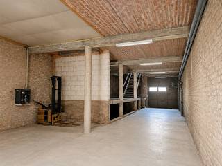 gelegen in het volle centrum, in woongebied<br />in verschillende niveaus : -1/2 en gelijkvloers en +1/2 en verdiep<br />toegangspoort van 3,4 m breed op 3,50 m hoog<br />gelijkvloers : +/- 175 m² en vrije hoogte van 3,55 m<br />verdieping : +/- 200 m² en vrije hoogte onder laagste deel dakgebinte 2,20 m<br />toilet aanwezig<br /><br />betonvloer, geïsoleerd dak, elektriciteit, verlichting, aardgas, warme luchtblazer, regenwater<br /><br />HP = 600 €/maand<br />onroerende voorheffing ten laste van de huurder