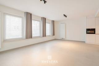 Voor meer info en foto’s, surf naar www.swevers.be – Op een uitstekende locatie aan de Oude Kuringerbaan 12 bus 2 in Hasselt bevindt zich dit volledig gerenoveerde appartement met twee slaapkamers. Het appartement ligt op de eerste verdieping van een residentie uit 1999 en beschikt over een bewoonbare oppervlakte van 76 m². Dankzij de grondige renovatie in 2026 is het volledig instapklaar, met nieuwe vloeren, een moderne keuken met toestellen, een vernieuwde badkamer en toilet en frisse schilderwerken. De lichtrijke leefruimte van 30,48 m² biedt voldoende plaats voor een gezellige zit- en eethoek en sluit aan op de open keuken van 5,67 m². Vanuit de leefruimte bereik je het overdekte balkon. Verder zijn er twee slaapkamers van 11,70 m² en 9,16 m², een badkamer met inloopdouche en dubbele lavabo, een apart toilet en een praktische berging. Het overdekte balkon vormt een aangename extra buitenruimte. Ook op vlak van comfort scoort dit appartement uitstekend. Het is energiezuinig, beschikt over conforme elektriciteit en is asbestveilig. Bovendien zijn een lift, videofoon, parlofoon en raamdecoratie aanwezig. De rustige ligging op amper 500 meter van het centrum van Hasselt is een grote troef. Winkels, restaurants, scholen en openbaar vervoer bevinden zich op korte afstand. Ook de snelwegen zijn vlot bereikbaar. Een ideale keuze voor wie op zoek is naar een modern, instapklaar appartement met twee slaapkamers op wandelafstand van het stadscentrum. Voor meer informatie, bel 011 255 155. Bron bewoonbare oppervlakte: EPC – verslag.