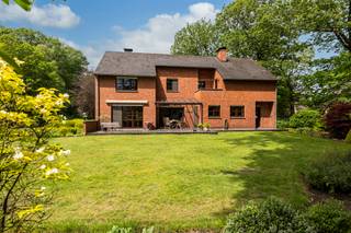 <p><strong>Verrassend ruime gezinswoning met o.a. 3 tot 4 slaapkamers en een dubbele inpandige garage. </strong><strong>Dit alles is gelegen op een prachtig perceel van ca. 1.972 m² met ideale oriëntatie, volledige privacy, en een uitermate rustige, unieke en residentiële ligging – in een straat waar enkel bewonersverkeer komt. En toch bereikt u op slechts enkele minuten het gezellige dorp van Oud-Turnhout en de E34 richting Antwerpen (±40 min) of Eindhoven (±20 min). Met een gunstige EPC-score van 152 kWh/m²/j — label B.<br /><br /></strong><span>Gelijkvloerse verdieping:</span> Via de zeer ruime en uitnodigende inkomhal betreedt u deze woning. De hal biedt voldoende plaats voor een vestiaire en geeft toegang tot een apart gastentoilet met handwasser. Vanuit de inkomhal bereikt u zowel de leefruimte als de keuken. De lichtrijke woonkamer is bijzonder ruim en opgedeeld in een gezellige eetkamer en een aangename zithoek met sfeervolle houthaard. Vanuit de leefruimte is er bovendien rechtstreekse toegang tot het gezellige overdekte terras, waar men in alle rust kan genieten van het zicht op de tuin.<br /><br />De keuken is praktisch ingericht en voorzien van de nodige toestellen, waaronder een kookvuur, oven en vaatwasser. Daarnaast beschikt ze over voldoende kastruimte. Aansluitend bevindt zich een praktische wasruimte, die tevens toegang biedt tot de tuin. Verder beschikt de gelijkvloerse verdieping over een inpandige dubbele garage, wat zorgt voor extra comfort en praktische bergruimte.<br /><br /><span>Eerste verdieping:</span> Vanuit de ruime inkomhal leidt de open trap naar de eerste verdieping. Dankzij de vide en de open verbinding met de hal blijft het contact tussen de verschillende niveaus mooi behouden, wat zorgt voor een bijzonder ruimtelijk en luchtig gevoel. Op deze verdieping bevindt zich de masterbedroom met aansluitende ensuite badkamer, uitgerust met een toilet, dubbele wastafel, bidet, ligbad en douche. Vanuit de badkamer is er bovendien rechtstreekse toegang tot een praktische wasplaats.<br /><br />Verder is er een tweede slaapkamer met ingemaakte kasten en een wastafel. Tot slot beschikt deze verdieping over een grote polyvalente ruimte, momenteel ingericht als bureau/kantoor met een gezellige zithoek. Deze ruimte biedt tal van mogelijkheden en kan desgewenst worden omgevormd tot extra kamers.<br /><br />Vanuit de nachthal is er eveneens toegang tot een balkon/terras.<br /><br /><span>Buitengebeuren:</span> De woning is gelegen op een prachtig aangelegd perceel met ideale zuidoostelijke oriëntatie, waar rust, groen en privacy centraal staan. De tuin wordt gekenmerkt door volwassen bomen en een groene, verzorgde aanleg. Verder beschikt het perceel over zowel een overdekt terras als een bijkomend terras met zonneluifel, waardoor er meerdere gezellige plekjes zijn om van de tuin te genieten. Tot slot is er een praktische tuinberging aanwezig, ideaal voor het opbergen van tuinmateriaal.<br /><br /><span>Bijzonderheden:<br /></span>- Centrale verwarming op aardgas d.m.v. radiatoren<br />- Zeer gunstige EPC-score: 152 Kwh/m²/j (label B)<br />- Kelder<br />- Woning is voorzien van rolluiken<br /><br />Neem een kijkje doorheen dit eigendom: https://visithome.ai/E589eaTB5yKHWPvtKikECq?mu=m</p>
