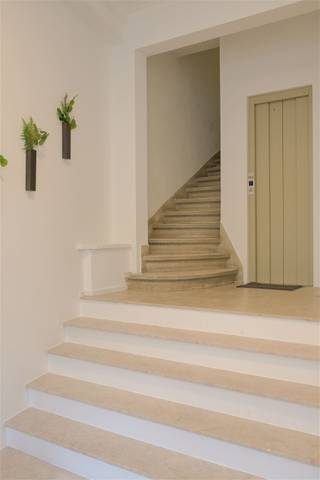 Stijlvol appartement in hartje BrusselOntdek dit prachtige twee-slaapkamerappartement, gelegen op de vierde verdieping van een volledig gerenoveerd gebouw van een kleine mede-eigendom. Geniet van een eigentijdse woonervaring, op wandelafstand van de Dansaertwijk, de Marollen en het Sint-Gillisvoorplein.De ruime woonkamer baadt in natuurlijk daglicht dankzij de grote ramen en biedt een schitterend uitzicht over de boomkruinen en Brusselse skyline. De leefruimte bevat een moderne uitgeruste keuken met opbergwand achter gordijn. Tussen het nacht- en daggedeelte loopt een ruime gang met een aangename plek aan een groot raam gericht op het westen.Aan de rustige achterzijde bevindt zich een ruime hoofdslaapkamer. De stijlvolle badkamer is uitgerust met een bad met geïntegreerde douche en dubbele wastafel. Er is een apart toilet. De tweede slaapkamer doet vandaag dienst als bibliotheek en home office.Het pand ligt in een levendige buurt met statig erfgoed, parken en pleinen en uitstekende verbindingen met fiets, tram, metro en trein. Parking is aanwezig in nabijheid van het pand, en mogelijks in huurformule in de parkeergarage van het gebouw. Het appartement is energiezuinig en baadt dankzij goede oost-west oriëntatie in ochtendlicht aan de voorzijde, en avondzon aan de achterzijde. De gemeenschappelijke kosten voor syndicus, liftonderhoud, schoonmaak, etc. zijn 140 euro per maand. Hier woont u in stijl, met alle comfort en charme van het Brusselse stadsleven binnen handbereik.