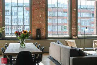 Indeling: Inkomhal met vestiaire en berg/wasruimte, lichtrijke living in parket met grote raampartijen, open volledig ingerichte keuken, trap naar de mezzanine met 2 slaapkamers  en verschillende ingemaakte kasten, badkamer (bad + douche) en afzonderlijke douchekamer aan de 2de slaapkamer. De loft geniet van aangenaam zonlicht (zuidgericht), en wordt geacclimatiseerd via de aanwezige zonnescreens, vliegenramen, airco en praktische kelderberging. Verder is er nog de mogelijkheid om een ruime autostaanplaats met laadmogelijkheden (gelegen net naast de lift) aan te kopen. Totale oppervlakte ca 180m² met een fantastisch 'loftgevoel'- wegens discretie staan niet alle ruimtes online. EPC-Score A<br /> 