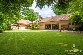 <p><strong>Riante energiezuinige villa met binnenzwembad en maximale privacy</strong></p>
<p>Op zoek naar luxe, ruimte en rust? Deze exclusieve villa, gelegen op een residentieel en rustig perceel van 2.477 m², biedt het allemaal. Met een bewoonbare oppervlakte van maar liefst 540 m² geniet je hier van comfortabel en energiezuinig wonen in een groene, discrete omgeving.</p>
<p>De woning werd gebouwd in 2006 en is voorzien van alle hedendaagse comfort. De ruime woonkamer met open leefkeuken baadt in natuurlijk licht en vormt het hart van het huis. De gehele gelijkvloerse verdieping is voorzien van gepantserd glas. Verder beschikt de villa over 5 volwaardige slaapkamers en 4 badkamers – ideaal voor grotere gezinnen of wie graag gasten ontvangt.</p>
<p>Voor ontspanning hoef je de deur niet uit: het luxe binnenzwembad zorgt voor een permanent vakantiegevoel. Ook thuiswerken wordt een plezier dankzij de grote kantoorruimte. Bovendien is er een aparte studio, perfect als gastenverblijf, praktijkruimte of voor inwonende hulp.</p>
<p>Buiten geniet je van een overdekt terras en een prachtig aangelegde tuin die volledige privacy garandeert. De dubbele garage maakt het plaatje compleet.</p>
<p>Bij het betreden van deze riante en energiezuinige villa komt u via de inkomhal meteen in de ruime leefruimte terecht. De woonkamer met gezellige zithoek en gashaard vloeit naadloos over in de eetplaats en de open leefkeuken, die voorzien is van alle hedendaags comfort – een ideale plek voor wie graag kookt en gasten ontvangt.</p>
<p>Een stijlvolle glazen wand scheidt de woonkamer van het binnenzwembad. Hoewel het zwembad momenteel buiten gebruik is, zijn alle technieken aanwezig om dit eenvoudig opnieuw in werking te stellen. Momenteel wordt de ruimte gebruikt als fitnessruimte, maar ze biedt ook andere mogelijkheden zoals wellness of hobbyruimte. Aansluitend bevinden zich een technische ruimte en een welnessgedeelte met sauna, douche en toilet. Een trap leidt hier naar een grote polyvalente ruimte op de verdieping, uitgerust met airconditioning en momenteel ingericht als kantoor.</p>
<p>Op het gelijkvloers is ook een ruime dubbele garage met toegang tot de kelder. Tussen de keuken en garage bevindt zich een tweede trap die leidt naar een studio, bestaande uit twee slaapkamers en een badkamer met douche, lavabo en toilet – ideaal als gastenverblijf of voor inwonende hulp.<br /><br />Vanuit de centrale inkomhal vertrekt een derde trap naar de bovenverdieping, waar u de masterbedroom vindt, uitgerust met parketvloer, airconditioning en gashaard. De master beschikt over een aanpalende dressing en een eigen badkamer met bad, douche en toilet. Daarnaast zijn er nog twee extra slaapkamers met parket en een aparte badkamer met ligbad, lavabo en toilet. Een gastentoilet is eveneens voorzien op het gelijkvloers.</p>
<p><strong>Buitenleven in alle comfort</strong></p>
<p>Grenzend aan de woonkamer bevindt zich een ruim overdekt terras, uitgerust met elektrische rolschermen en terrasverwarming – ideaal om het hele jaar door van buiten te genieten. Een tweede terras ligt aan het binnenzwembad. De aangelegde tuin rondom de woning biedt volledige privacy en rust. Verder beschikt het domein over een carport en een professioneel alarmsysteem.</p>
<p>Een unieke combinatie van ruimte, luxe en rust. Klaar om jouw nieuwe thuis te worden?</p>