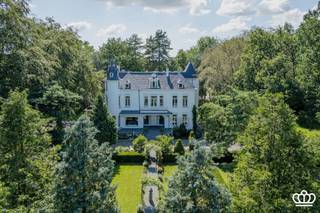 <p><span>Kasteel Ertbrand, u</span><span>niek kasteeldomein van ca. 5,7 ha in Kapellen</span></p><p><span> </span></p><p><span>Midden in een prachtig aangelegd parkdomein van ca. 57.000 m² ligt Kasteel Ertbrand. Het domein omvat het statige kasteel, een karaktervol voormalig koetshuis en een volwaardige tuinmanswoning.</span></p><p><span>Een eigendom van deze omvang en uitstraling is zeldzaam. Met zijn rijke geschiedenis, 3 royale residenties en uitgestrekte parkdomein vormt dit een unieke opportuniteit voor wie op zoek is naar een prestigieuze privéresidentie met tal van mogelijkheden.</span></p><p><span> </span></p><p><span>Het Domein</span></p><p><span> </span></p><p><span>Het prachtig aangelegde park vormt een oase van rust en privacy, met onder meer sierlijke vijvers, verzorgde hagen, volwassen groenstructuren en sfeervolle verzichten.</span></p><p><span>Hier geniet men van een uitzonderlijke woonomgeving waar natuur en exclusiviteit hand in hand gaan. </span></p><p><span>Een bijkomende meerwaarde is dat het kasteel, het koetshuis en de tuinmanswoning reeds zijn verkaveld in drie afzonderlijke percelen. Hierdoor biedt het eigendom niet alleen een unieke residentiële ervaring, maar ook interessante mogelijkheden naar de toekomst toe, waaronder een eventuele afzonderlijke verkoop van de verschillende residenties.</span></p><p><span> </span></p><p><span>Het Kasteel</span></p><p><span> </span></p><p><span>Het voormalige "Kasteel van Biart" werd na de Eerste Wereldoorlog afgebroken. Op deze historische locatie werd in 1920 het huidige Kasteel Ertbrand opgericht. De statige residentie beschikt over een bewoonbaar oppervlakte van circa 1.200 m² en straalt nog steeds de elegantie en grandeur uit van zijn bouwperiode.</span></p><p><span>Het kasteel omvat onder meer 10 slaapkamers en 4 badkamers, aangevuld met ruime leefvertrekken en ontvangstruimtes. De royale volumes, authentieke elementen en tijdloze uitstraling maken van het kasteel een uitzonderlijke woonervaring.</span></p><p><span>Naast zijn historische charme werd het kasteel doorheen de jaren zorgvuldig onderhouden. Zo werd het dak circa 10 jaar geleden vernieuwd, werden 20 zonnepanelen geplaatst en zorgen drie recente cv-ketels op aardgas voor een efficiënte en comfortabele verwarming.</span></p><p><span> </span></p><p><span>Het Koetshuis</span></p><p><span> </span></p><p><span>Naast het kasteel bevindt zich het voormalige koetshuis, met een bewoonbaar oppervlakte van circa 733 m². Dit gebouw werd in 2012 gerenoveerd en combineert vandaag karaktervolle elementen met hedendaags wooncomfort.</span></p><p><span>Het koetshuis omvat een ruime woning met 3 slaapkamers en 2 badkamers, aangevuld met een afzonderlijk appartement met 2 slaapkamers en 1 badkamer. Dankzij deze indeling biedt het talrijke mogelijkheden: van een gastenverblijf tot kangoeroewonen of een aparte woongelegenheid voor familieleden.</span></p><p><span>Als extra troef beschikt het koetshuis over een groot binnenzwembad, een sauna en meerdere garages.</span></p><p><span> </span></p><p><span>De Tuinmanswoning</span></p><p><span> </span></p><p><span>Het domein wordt vervolledigd door een charmante tuinmanswoning met een bewoonbaar oppervlak van circa 318 m². Deze volwaardige derde residentie beschikt over 3 slaapkamers en 2 badkamers en biedt eveneens diverse mogelijkheden binnen het geheel.</span></p><p><span> </span></p><p><span>Ligging</span></p><p><span> </span></p><p><span>Het domein is landelijk en in het groen gelegen, op een strategische locatie in Putte-Kapellen, nabij diverse voorzieningen en met een vlotte verbinding richting Brasschaat, Antwerpen en Nederland.</span></p><p><span> </span></p><p><span> </span></p><p><span>Contacteer ons voor meer informatie of om dit bijzondere domein persoonlijk te ontdekken.</span></p><p><span> </span></p>