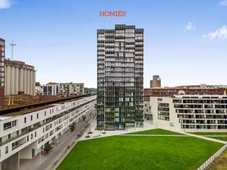Met plezier bieden we u dit prachtige appartement aan in het recente gebouw De Lucid, gelegen op de 13de verdieping, met schitterende vergezichten over de Leuvense binnenstad. Het appartement bevindt zich op een rustige ligging aan de Leuvense Vaartkom en op wandelafstand van het bruisende centrum en het station, wat zorgt voor een ideale combinatie van rust en bereikbaarheid. Binnenin geniet u van vloerverwarming en een aangename leefruimte met drie slaapkamers, waaronder één ruime en twee kleinere kamers. De lichtrijke leefruimte geeft bovendien toegang tot een ruim terras, waar u kan genieten van het open uitzicht over Leuven. De indeling wordt verder aangevuld met twee badkamers: een volledig uitgeruste badkamer met bad, toilet en dubbele lavabo, en een tweede badkamer met douche en lavabo. Daarnaast is er ook een apart gastentoilet voorzien. Het comfort wordt verhoogd door twee ondergrondse staanplaatsen, 3 fietsstaanplaatsen en een privatieve kelder op niveau -1. Het appartement wordt onbemeubeld verhuurd, met uitzondering van enkele praktische voorzieningen zoals een dubbel bed met nachtkastjes, gordijnen, een zetelbed, wasmachine en droogkast. De nutsvoorzieningen voor water en elektriciteit dienen apart afgesloten te worden. Voor verwarming en algemene kosten geldt een maandelijkse provisie van €150. Het appartement is beschikbaar vanaf 1 augustus 2026. Wenst u graag een bezoek of extra informatie? Aarzel dan zeker niet om contact op te nemen via info@homies.be!
