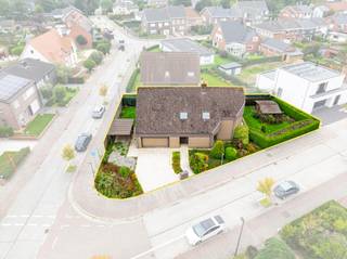 In een rustige woonwijk, op wandelafstand van het station, vinden we op een mooi hoekperceel deze uitzonderlijk ruime gezinswoning met maar liefst 7 slaapkamers.<br /><br />De villa werd opgetrokken in de jaren tachtig, met één duidelijke focus: ruimte voor het hele gezin. Dat vertaalt zich vandaag in royale leefruimtes, een bijzonder praktische indeling en heel wat mogelijkheden om de woning naar eigen smaak te moderniseren.<br /><br />Via de ruime inkomhal met ingebouwde vestiairekast betreden we de woning. Rechts bevindt zich een afzonderlijke zitruimte, die aansluit op de ruime, tweedelige leefruimte. Verder vinden we een grote, aparte leefkeuken met aansluitend een bijzonder praktische en ruime koele berging.<br /><br />Naast de keuken bevinden zich de ingerichte wasberging en een eerste badkamer met douche. Van hieruit is er rechtstreeks toegang tot de dubbele garage, die zowel langs de voor- als achterzijde bereikbaar is.<br /><br />De verschillende leefruimtes op het gelijkvloers zijn vandaag afzonderlijk ingedeeld, maar bieden dankzij hun oppervlakte en indeling heel wat potentieel. Wie houdt van een hedendaags en open ruimtegevoel kan hier verschillende ruimtes samenbrengen tot één royale leefomgeving.<br /><br />Ook op de eerste verdieping blijft ruimte het sleutelwoord. Hier bevinden zich maar liefst 7 slaapkamers, een tweede badkamer, een afzonderlijk toilet en een extra berging. Een uitzonderlijke indeling die deze woning bijzonder geschikt maakt voor grote of nieuw samengestelde gezinnen, maar evengoed voor wie nood heeft aan extra bureel, hobby of logeerruimte.<br /><br />Buiten geniet u van een aangenaam aangelegde tuin met terras. Dankzij het hoekperceel is er bovendien een mooi gevoel van ruimte rondom de woning. Parkeren kan op eigen terrein en bijkomend in de straat.<br /><br />Bent u op zoek naar een bijzonder ruime gezinswoning met 7 slaapkamers, een dubbele garage en tal van mogelijkheden, en dit op een centrale maar rustige ligging? Dan verdient deze woning absoluut uw bezoek.<br /><br />Extra troeven:<br /><br />Maar liefst 7 slaapkamers<br /><br />Dubbele garage<br /><br />Ruime en veelzijdige leefruimtes<br /><br />Drijfkracht aanwezig<br /><br />Regenwaterput van 10.000 liter<br /><br />Aangename tuin en terras<br /><br />Parkeermogelijkheden op eigen terrein