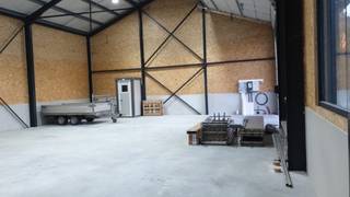 te huur nieuw magazijn van +/- 180 m² met een hoogte van +/- 8m, grote elektrische sectionale deur regenwatertank +/- 10.000 liter led...