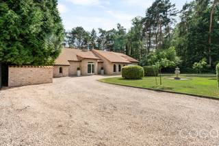 <p><strong>Prachtig gerenoveerde gelijkvloerse villa op een schitterend perceel van 1.964m² met een straatbreedte van maar liefst 35 meter</strong>! <br />Omgeven door groen en rustig gelegen midden tussen Brecht en Sint-Job-in-‘t-Goor. <br />Winkels, scholen, openbaar vervoer zijn allen relatief kortbij te vinden. <br />Verder een vlotte verbinding naar de E19 Antwerpen-Breda alsook het treinstation ‘Noorderkempen’.</p>
<p><em><strong><u>SAMENSTELLING &amp; BESCHRIJVING</u></strong></em>:</p>
<p>We betreden de woning via de ruime inkomhal en komen in een <strong>riante leefruimte (ca. 55m²)</strong> met een kijk op de voor – en achtertuin. Inkomhal en leefruimte zijn voorzien van <strong>vloerverwarming </strong>en een parkettegel. De centrale <strong>gashaard </strong>zorgt voor warmte en sfeer in de koude wintermaanden.</p>
<p>Aansluitend een <strong>moderne keuken</strong> volledig uitgerust met volgende toestellen: keramische kookplaat – dampkap – spoeltafel – vaatwasser (nieuw) – koffieapparaat – oven – microgolfoven en Amerikaanse koelkast. De natuurstenen vloer in dito werkblad zorgen voor <strong>zuiderse accenten</strong>.</p>
<p>Vervolgens de <strong>luxueus afgewerkte badkamer</strong> ingericht met dubbele wastafel in een breed meubel met spiegelkasten – inloopdouche en toilet.</p>
<p>Vanuit de leefruimte kom je in de <strong>hoofdslaapkamer met ensuite dressing</strong> voorzien van inbouwkasten.</p>
<p>Daarnaast een <strong>ruime garage</strong> (4,75m x 6,00m) met geautomatiseerde sectionaalpoort.<br />Vanuit de garage kom je met een vlizotrap op de bergzolder. Mits het plaatsen van een vaste trap kan je hier nog een extra kamer realiseren.</p>
<p>Een hal verbindt de inkomhal met de hobbyruimte waarbij we passeren langs de wasberging en een ruim gastentoilet.</p>
<p>De <strong>hobbyruimte </strong>bergt de nutsvoorzieningen en de boiler op achter ingemaakte kasten.<br />Een vaste trap brengt je op de verdieping met <strong>nog slaapgelegenheid</strong>. <br />Achteraan nog de cv-installatie op gas (ATAG – condensatiemodel – bwj. 2022).</p>
<p><em><strong><u>BUITEN</u>:</strong></em></p>
<p>Aan de achterzijde van de woning is het heerlijk vertoeven op het <strong>schitterend terras van 50m²</strong>, afgewerkt met blauwe hardsteen, in alle privacy en omgeven door groen.</p>
<p>Het <strong>overdekt terras van ca. 25m²</strong> nodigt uit <strong>voor een gezellig samenzijn</strong>, een zomerse bbq, en geeft verkoeling wanneer het echt te warm is.</p>
<p>In de voortuin een halfronde oprit met in – én uitrit wat <strong>veel parkeermogelijkheden</strong> biedt.</p>
<p><em><strong><u>EXTRA</u>:</strong></em></p>
<p>De woning is voorzien van <strong>18 zonnepanelen</strong> met een max. vermogen van 5.850 Wp.<br />In de woonkamer werd onlangs nog een <strong>airco </strong>geplaatst (warmtepomp lucht/lucht) waarmee je zowel kan koelen als verwarmen.</p>
<p>Wil je levenslang luxueus wonen in het groen?<br />Mis deze kans niet en <strong>kom deze woning verder ontdekken</strong> bij een bezichtiging!</p>