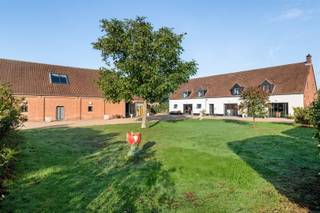 <p><span>BOECHOUT/VREMDE</span><span>: Uniek domein bestaande uit hoeve, schuur en stallen</span></p><p><span>In het hart van het landelijke Vremde ontvouwt zich achter een uitgestrekt perceel van circa 19.000 m² een eigendom dat zelden zijn gelijke kent. </span></p><p><span>Dit landgoed biedt niet alleen ruimte, maar ook een levensstijl waarin rust, architectuur en natuur elkaar versterken.</span></p><p><span>Het domein bestaat uit drie afzonderlijke gebouwen die samen één krachtig geheel vormen. De voormalige hoeve werd grondig vernieuwd en uitgebreid, met respect voor het verleden en oog voor hedendaags comfort. Authentieke balken en karaktervolle materialen gaan er hand in hand met grote raampartijen en een open, lichtrijk interieur.</span></p><p><span>Op het gelijkvloers vindt u onder meer een ruime leefkeuken, praktische wasplaats, apart toilet, bureau, een royale leefruimte en een sfeervolle wijnkelder. </span></p><p><span>De verdieping herbergt een aparte studio met slaapkamer en badkamer, beide met uitzicht op het omliggende groen. Daarnaast zijn er nog twee bijkomende slaapkamers, een douche, dressing, sauna en een extra toilet.</span></p><p><span>Wat vandaag als schuur wordt omschreven, is in werkelijkheid een indrukwekkende multifunctionele ruimte met eigen keuken. Perfect als atelier, tentoonstellingsruimte, privéverzameling of inspirerende plek voor workshops en coachings. Het charmante voormalige bakkershuisje beschikt over twee slaapkamers en een badkamer, ideaal als gastenverblijf, kangoeroewoning of rustige werkplek.</span></p><p><span>Verder beschikt het domein over een recent gebouwd, hoogwaardig stallencomplex met piste. De biologische moestuin, omringd door fruitbomen en bloemen, maakt het plaatje compleet voor wie bewust en groen wil leven. Overname van de inboedel is bespreekbaar.</span></p><p><span>Een eigendom met eindeloze mogelijkheden en uitstraling komt maar zelden beschikbaar een unieke kans voor wie op zoek is naar een buitengewone woon- en belevingsplek.</span></p><p><span> </span></p><p><span>BIJZONDERHEDEN:</span></p><p><span> </span></p><p><span>- Rustige ligging te midden de natuur, omgeven door groen en uitgestrekte velden</span></p><p><span>- De eigendommen werden volledig gerenoveerd en verkeren in perfecte toestand</span></p><p><span>- Multifunctioneel en geschikt voor meerdere doeleinden</span></p><p><span> </span></p>