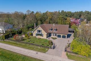 <p>Deze prachtige woning van ca. 300 m² is gelegen in de villawijk van Poppel (Aarleheide), op een perceel van ca. 1.800 m², in een rustige en landelijke omgeving met open zicht op de omliggende weilanden. De woning werd door de jaren heen goed onderhouden en verkeert in een verzorgde staat. Dankzij de ligging aan de rand van het bos geniet de woning bovendien van een aangename lichtinval en een natuurlijk gevoel van ruimte en groen rondom. De verschillende wandel- en natuurgebieden in de nabije omgeving maken dit tevens een geweldige locatie voor hondenbezitters en wandelaars.</p>
<p>Bij aankomst komt u binnen via een elektrische toegangspoort die leidt naar een ruime oprit met dubbele garage (voorzien van vernieuwde elektrisch bedienbare deuren) en dubbele carport met extra bergruimte (schuur).</p>
<p>In de inkomhal zijn een vestiaire en gastentoilet voorzien. Aansluitend bevindt zich een polyvalente ruimte, perfect geschikt als bureau, praktijkruimte of speelkamer.</p>
<p>De woonkamer is afgewerkt met een mooie eikenhouten vloer. De grote raampartijen (voorzien van elektrische luifel) zorgen voor een overvloed aan natuurlijk licht, terwijl de gashaard extra sfeer creëert. Vanuit de leefruimte geniet u bovendien van een fantastisch zicht op de weilanden. Een uitzicht dat nooit verveelt en elk seizoen anders is. Via de schuifpui in de woonkamer heeft u rechtstreeks toegang tot de overkapping en de tuin.</p>
<p>De landelijke leefkeuken biedt veel kastruimte en is uitgerust met hoogwaardige toestellen, waaronder een Miele koffiemachine, Smeg oven en magnetron en een Miele inductiekookplaat.</p>
<p>Aansluitend is er een praktische bijkeuken met aansluitingen voor wasmachine en droogkast, een ingebouwde frituur en grillplaat en extra opbergruimte.</p>
<p>De woning beschikt tevens over een uitzonderlijk ruime kelder.</p>
<p>Eenmaal boven wordt u verrast door de royale overloop die direct een aangenaam en ruimtelijk gevoel geeft. Deze centrale ruimte verleent toegang tot alle vertrekken, te beginnen met de master bedroom. Compleet met airconditioning, een privébalkon met rustgevend uitzicht op het groen, elektrische luifel en een comfortabele en-suite badkamer met bubbelbad, dubbele wastafel, douche en toilet.</p>
<p>Daarnaast beschikt de verdieping over nog drie andere volwaardige slaapkamers, allen voorzien van praktische ingebouwde kasten, waarbij één kamer extra is uitgerust met een eigen wastafel.</p>
<p>De tweede badkamer is recent en smaakvol vernieuwd met een ruime inloopdouche, een dubbel wastafelmeubel en stijlvolle koperkleurige details. Met recht een parel in de woning en een echte blikvanger.<br /><br />De geïsoleerde zolder, bereikbaar via een vlizotrap, biedt over de volledige woning extra opslagruimte.<br /><br />De prachtig aangelegde en volledig omheinde tuin biedt een echte oase van rust en privacy, met een mooie notenboom, verschillende terrassen en een verzorgd gazon. Dankzij de grondwaterput, het automatisch sproeisysteem en de robotmaaier is het onderhoud bijzonder eenvoudig.<br /><br />Recente investeringen omvatten o.a. een cv-installatie (2022), dakkapel (2023), tweede badkamer (2025), aluminium ramen boven (2026) en elektrische garagepoorten (2026).</p>
<p>Kortom, een unieke combinatie van ruimte en rust op een toplocatie.<br /><br />Contacteer ons vandaag nog voor een bezoek en laat u ter plaatse overtuigen door deze prachtige woning.</p>