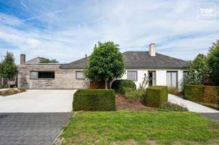 Vrijstaande, instapklare woning met verwarmd zwembad in Lovendegem<br /><br />In de rustige Tempeliersdreef bevindt zich deze vrijstaande woning op een perceel van 766 m².<br /><br />De woning is volledig gelijkvloers ingericht en beschikt over een bewoonbare oppervlakte van 165 m². Charmante, authentieke elementen zorgen doorheen de woning voor extra karakter.<br /><br />De ruime en lichtrijke leefruimte vormt het hart van de woning en sluit mooi aan op de kwalitatief ingerichte keuken.<br /><br />Verder beschikt de woning over een afzonderlijke bureauruimte, een praktische wasplaats en een extra berging.<br /><br />De drie slaapkamers zijn heel mooi afgewerkt , waarbij één slaapkamer bovendien beschikt over een aanpalende dressing.<br /><br />De centraal geplaatste airco in de gang zorgt tijdens warme dagen voor een aangename verkoeling in de verschillende kamers.<br /><br />Buiten geniet je van een ruime en zonninge tuin met terras en verwarmd zwembad, ideaal om in alle rust van de buitenruimte te genieten.<br /><br />De oprit in steentapijt biedt plaats aan drie wagens en is bovendien voorzien van een laadpaal.<br /><br />Daarnaast is er nog een afzonderlijke staanplaats, ideaal voor bijvoorbeeld een aanhangwagen.<br /><br />De twaalf zonnepanelen dragen bij aan het energiezuinige karakter van de woning.<br /><br />Ook de ligging is een belangrijke troef. De woning bevindt zich vlak bij de dorpskern van Lovendegem, met winkels, scholen en openbaar vervoer in de nabije omgeving.<br /><br />Via de N9 zijn zowel Gent als Eeklo vlot bereikbaar.<br /><br />Hier woon je rustig en comfortabel, met alle ruimtes op het gelijkvloers en een aangename buitenruimte waar privacy en ontspanning centraal staan.<br /><br />Bel Top Vastgoed voor een bezoek op 0475 700 700.