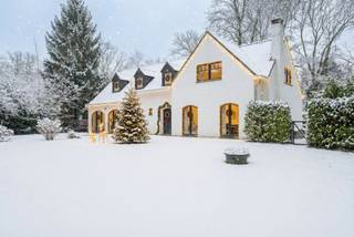 Via de geautomatiseerde poort betreden we de zonnige tuin met toegang naar de charmante villa op 1.753 m². De woning werd in 2025 volledig (ramen, volledige CV installatie incl leidingen, elek installatie, trap, vloeren, keuken, badkamers) en smaakvol gerenoveerd, met behoud van haar warme karakter en een hedendaagse afwerking.<br /><br />Indeling gelijkvloers:<br />De inkomhal geeft toegang tot een lichtrijke leefruimte met open haard, eiken balken en grote raampartijen die uitgeven op de tuin. De eetkamer sluit naadloos aan en vormt samen met de woonkamer een aangename leefzone met zicht op het groen.<br />De vernieuwde keuken, uitgevoerd in zachte tinten met houten accenten, is uitgerust met kwalitatieve toestellen en biedt veel werk- en bergruimte.<br />De dubbele garage werd reeds verbouwd en voorbereid voor verdere afwerking. Ze kan eenvoudig verder worden omgevormd tot een groot thuiskantoor, speelkamer voor kinderen of een volwaardige logeerkamer met badkamer — of een combinatie daarvan.<br /><br />Eerste verdieping:<br />Op de verdieping bevinden zich vier slaapkamers, waaronder een ruime master met ingemaakte kasten en ensuite-badkamer. De overige kamers kunnen perfect dienen als kinder-, logeer- of werkkamer. Een tweede badkamer en een praktische douchekamer (eventueel te gebruiken als wasplaats) vervolledigen deze verdieping.<br /><br />Tuin:<br />De zuidoostgerichte tuin vormt een groene buffer tussen de woning en de omgeving en biedt een verrassend gevoel van privacy. Dankzij het ruime perceel en het overdekte terras met haard geniet men hier van volop van de buitenruimte.<br /><br /><br />Deze woning combineert een warme, recente afwerking met een uitstekende bereikbaarheid en een groot perceel, wat haar bijzonder interessant maakt voor wie comfortabel en stijlvol wil wonen in Zoersel.