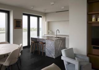 Wonen met de Schelde als dagelijks decor. Op de 12de verdieping van residentie Scheldehof op Nieuw Zuid ontdekt u dit instapklare appartement met twee slaapkamers, een hoogwaardige afwerking en een zonnig zuid/zuidwestelijk terras.<br /><br />Grote raampartijen brengen het licht en het frontale rivierzicht tot diep in de leefruimte. Het donkere visgraatparket, de strakke kastenwanden en de verfijnde materialen geven het interieur een warme, tijdloze uitstraling. De open luxekeuken is volledig uitgerust met toestellen en een stijlvol eiland: een aangename plek om te koken, bij te praten en van het uitzicht te genieten.<br /><br />Op het terras kijkt u uit over het water en komt u helemaal tot rust, hoog boven de stad.<br /><br />Het appartement beschikt over twee slaapkamers en een luxueus ingerichte badkamer met een XL-inloopdouche en een afzonderlijk ligbad. Verder zijn er één toilet, veel kastruimte en een praktische berging met bijkomende opbergkasten. Vloerverwarming en airconditioning zorgen voor comfort in elk seizoen.<br /><br />Twee parkeerplaatsen op niveau -1 en een kelderberging zijn inbegrepen in de vraagprijs.<br /><br />Vraagprijs: € 1.250.000, exclusief registratierechten en overige aankoopkosten.<br />• Aankoopprijs inclusief 12% registratierechten: € 1.400.000.<br />• Indien u aan alle voorwaarden voor het tarief van 2% voldoet: € 1.275.000 inclusief registratierechten.<br />Deze bedragen zijn exclusief notariskosten en overige aktekosten.<br /><br />Beschikbaar na het verlijden van de authentieke akte.<br /><br />Ontdek zelf het uitzicht en de afwerking van dit bijzondere appartement. Contacteer ons voor een bezoek.