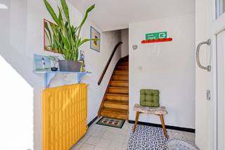 Solide bel-etagewoning van 1968 met een totale bruikbare oppervlakte van 174m, gebouwd op een perceel van 1a95ca in een rustige wijk met achteraan zicht op de velden. Op de gelijkvloerse verdieping vindt u de inkomhal met aparte wc, een garage voor 1 wagen + 2 staanplaatsen voor het huis, stookplaats, badkamer en 2 opbergruimtes. Op de eerste verdieping vindt u de leefruimte (29m²) met rechtstreekse toegang tot een veranda en de tuin en een ingerichte keuken. De tweede verdieping bestaat uit 2 slaapkamers (17m² en 11m²) en een badkamer met ligbad, wc en 1 lavabo. Er is vaste trap naar een grote zolderkamer (29m²) die mogelijks nog kan opgesplitst worden in 2 slaapkamers. Er is overal dubbele beglazing (PVC) en de woning verwarmd met een condenserende gasketel. Uitstekende EPC-score B!