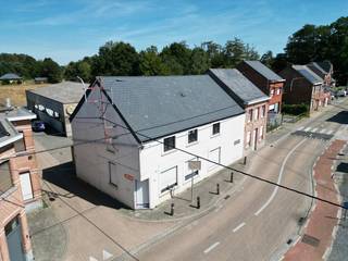 Handelseigendom bestaande uit een feestzaal en een handelszaak (vroeger café). De handelszaak is verhuurd. Meer informatie over het huurcontract te bekomen via het kantoor. De eigenaar baat momenteel de feestzaal uit. Vg, Wglk/Lwag, Gdv, Gvkr, Gvv. EPC handelzaak: 503 (label F). EPC feestzaal: 505 (label X). Vlotte bereikbaarheid met privaat en openbaar vervoer door zijn ligging in het centrum van het gehucht Sint-Adriaan. P en G-score: A.<br /><br />INDELING HANDELSZAAK:<br />Kelder (gas- en watermeter)<br />Gelijkvloers:<br />Polyvalente ruimte (toog, inkomdeur), damestoilet (2 wc's en lavabo), herentoilet (1 wc, 2 urinoirs en lavabo), bureauruimte met kitchenette (roestvrije spoelbak, aanbouwkasten), bergplaats met afzonderlijk toilet, (douche lavabo, condensatiegaswandketel), sas (trap naar verdieping, buitendeur), bureauruimte op de tussenverdieping.<br />Verdieping: <br />Overloop, slaapkamer 1, slaapkamer 2, slaapkamer 3, slaapkamer 4, sas, toilet (wc en lavabo), stockagezolder.<br /><br />INDELING FEESTZAAL:<br />Gelijkvloers:<br />Portaal, feestzaal met toog en podium, sanitaire bloc (dames- en herentoilet), stockageruimte, berging (trapluik dakverdieping, installatie elektriciteit, buitendeur), stookplaats (stookketel), keuken (buitendeur, aanbouwkasten, waterverzachter, doorstroomboiler, keukeninstallatie).<br /><br />Stockagezolder<br /><br />AFWERKING :<br />- Vloer : keramische tegels, lichte vloerbekleding, laminaat.<br />- Muren : bepleisterd, geschilderd, behangen, volledig betegeld in sanitaire blok, geschilderd pleisterwerk en snelbouw.<br />- Plafond : plafondtegels, houten balkenplafond, geschilderd pleisterwerk, metalen planchetten, houten planchetten.<br /><br />DIVERSEN :<br />Centrale verwarming met convectoren op stookolie voor de feestzaal. Centrale verwarming op gas met radiatoren in de handelszaak. Draai- en kiepramen in pvc en aluminium met dubbele beglazing. Rolluiken in pvc met lint. <br /><br />STEDENBOUWKUNDIG :<br />Stedenbouwkundige vergunning : ja (handelszaak voor 1962 - feestzaal 1987)<br />Stedenbouwkundige bestemming : grotendeels woongebied met landelijk karakter en achteraan voor een klein deel in landschappelijk waardevol agrarisch gebied<br />Dagvaarding en herstelvordering : nee<br />Voorkooprecht : nee<br />Verkavelingsvergunning : nee<br />P en G-score: A.<br />De handelszaak is verhuurd met een handelshuurcontract maar momenteel in gebruik als woning door de huurder. De feestzaal is in gebruik tot eind 2026.