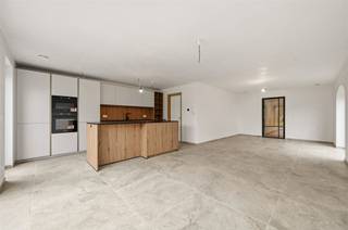 <p><span>Deze halfopen nieuwbouwwoning verrast op verscheidene fronten. Afgezien van de circa 6 meter diepe garage, is er op de 2 opritten nog plaats voor 2 auto's. In de gevel zijn zowel het portiek rond de voordeur als de lintelen boven de ramen, uitgevoerd in blauwe hardsteen. Het energetische doelpeil van E2 (Label A) werd onder meer bereikt door het voorzien van algemene vloerverwarming, warmtepomp, airco's (warmtepomp) in living en kamers, superisolerend glas, 12 zonnepanelen en ventilatiesysteem D. Qua stijlelementen spotten we een gevelsteen (recuperatielook) vermetst in wildverband, kleinhouten tussen de glasplaten, werkblad en trap in gehamerde natuursteen, glazen deur (living), etc.  De ruime leefruimte en greeploze keuken met eiland, kijken via verscheidene grote ramen uit op de tuin (gras) en het grote betegelde terras. Het kookvuur beschikt over centrale afzuiging. Voor het overige, stelen de volgende apparaten de show: combi-oven, oven, XL-koelkast en vaatwasser. De handige wasplaats/berging sluit aan op keuken én garage. In de badkamer beschikt u over een acrylbad, een breed dubbel houten meubel en een inloopdouche met regenfunctie en ingebouwde kranen. Buiten de drie kamers met airco waarvan één met dressing  staat nog de gehele tweede verdieping ter beschikking, als één grote kamer. In de nachthall en langsheen de trap, werkt de verlichting middels een bewegingsmelder. De Verbindingsstraat is een rustige woonstraat in een zone 30. Deze nieuwbouwwoning wordt verkocht onder een gemengd fiscaal stelsel, waarbij de grondwaarde onderworpen is aan 12% registratierechten en de constructiewaarde aan 21% btw.</span></p>