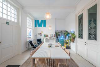 <p>Quares - TREVI Groep presenteert dit unieke pand op een absolute toplocatie in Mechelen. <br />Gelegen aan de Dijle, op wandelafstand van de Vismarkt, de Melaan en de jachthaven, geniet deze eigendom van een uitzonderlijke ligging achter een prachtige historische gevel. Vanuit het pand kijkt u uit op de rivier, de Kraanbrug en de iconische houten huisjes die het stadsbeeld van Mechelen mee bepalen.</p>
<p>Op het gelijkvloers worden 2 ruimtes te huur aangeboden. Momenteel worden deze ingevuld als kantoorruimte, maar ze bieden tal van mogelijkheden voor andere commerciële invullingen. Denk aan een boetiek, galerij, broodjeszaak, praktijkruimte of een innovatief concept dat perfect aansluit bij de levendige omgeving.</p>
<p>De voorste ruimte van ca. 28 m² baadt in natuurlijk licht dankzij de grote raampartijen, en charmeert met authentieke moulures en hoge plafonds. Achteraan bevindt zich een tweede ruimte van ca. 36 m² die zich uitstekend leent als atelier, backoffice of aanvullende werkruimte. Hier zijn reeds een keuken, vestiaire en gastentoilet aanwezig.</p>
<p>Beide ruimtes worden verbonden door een statige inkomhal die tevens toegang biedt tot de bovenliggende appartementen. Deze hal kan fungeren als representatieve toegang voor bezoekers of als afzonderlijke ingang voor medewerkers via de poort aan de zijgevel.</p>
<p>Dankzij de rustige ligging, de aangename sfeer en de hoge plafonds biedt dit pand een comfortabele werkplek voor een team tot ongeveer acht personen. Bovendien kunnen in de directe omgeving ondergrondse parkeerplaatsen gehuurd worden.</p>
<p><strong>Praktisch</strong></p>
<ul>
<li>Maandelijkse huurprijs: € 1.450</li>
<li>Maandelijks lastenforfait: € 100</li>
<li>Jaarlijkse onroerende voorheffing: ca. € 1.450</li>
<li>Beschikbaar vanaf 1 augustus 2026, maar start januari 2027 of daar tussenin vormt eveneens geen probleem</li>
<li>Huurwaarborg: 3 maanden</li>
</ul>
<p>Bent u op zoek naar een karaktervolle ruimte op een unieke locatie in het centrum van Mechelen? Contacteer Tinne Schotsmans via 0477 60 21 99 of tinne.schotsmans@quares-trevi.be voor meer informatie of een bezoek ter plaatse.</p>
<p>Tot binnenkort!</p>