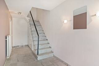 Deze toffe, ruime bel-etagewoning is erg goed gelegen in een residentiële wijk, niet ver van het centrum van Stabroek. Hoewel het hier erg rustig wonen is, zijn winkels, openbaar vervoer en scholen allemaal in de directe omgeving aanwezig. U komt de woning binnen via een aparte inkomhal, voorzien van praktische ingemaakte kasten onder de trap. Vanuit deze hal heeft u toegang geeft tot een grote inpandige garage met automatische poort en de achterliggende berging/wasplaats en technische ruimte. Via de trap bereikt u het leefgedeelte op de 1e verdieping. De ruime woonkamer kan dankzij grote ramen genieten van flink wat lichtinval. De aanwezige sierschouw zorgt bovendien voor een extra gezellige uitstraling. Verder bevinden zich op de 1e verdieping nog een comfortabel ingerichte, open keuken en een apart gastentoilet. Via de glazen deur in de keuken heeft u tevens toegang tot het gezellige terras. De tweede verdieping telt 3 volwaardige slaapkamers en een badkamer met ligbad met douche, toilet en wastafel met meubel. Het perceel heeft een totale oppervlakte van 210m². De tuin is mooi omsloten en werd voorzien van een verhard terras en een praktische tuinberging. Dankzij de oriëntatie op het westen kan u in de tuin tot laat op de avond van het zonnetje genieten. De inpandige garage biedt handig plek aan uw wagen. Ook op de oprit voor de woning is er nog een extra staanplaats op eigen terrein.