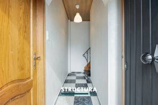 Gezinswoning met 4 slaapkamers in rustige, doodlopende straat te MerchtemBent u op zoek naar een ruime gezinswoning met potentieel, gelegen op een rustige locatie nabij alle voorzieningen? Dan is deze halfopen bebouwing in een doodlopende straat zeker een bezoek waard. Met een bewoonbare oppervlakte van ca. 149 m², vier slaapkamers, een conforme elektrische installatie en een aangename ligging op wandelafstand van het centrum van Merchtem, winkels, scholen en openbaar vervoer, biedt deze woning een uitstekende basis. IndelingGelijkvloers: een inkomhal, een badkamer met douche, lavabo en toilet, een ruime en lichtrijke leefruimte met kachel, gevolgd door een aparte keuken met toegang naar buiten. Achteraan bevindt zich nog een praktische bergplaats. De indeling van het gelijkvloers biedt tal van mogelijkheden voor verdere modernisering en optimalisatie.De eerste verdieping omvat vier volwaardige slaapkamers, ideaal voor een gezin of voor wie extra ruimte zoekt voor een bureau of hobbykamer. Via een valtrap bereikt u de ruime zolderverdieping, die momenteel dienstdoet als bergruimte maar potentieel biedt voor verdere inrichting.Buiten geniet u van een onderhoudsvriendelijke voortuin, een privatieve oprit en een aangename buitenruimte rondom de woning.Karakteristieken- Halfopen bebouwing- Bewoonbare oppervlakte: ca. 149 m²- Perceeloppervlakte: 2a29ca- Rustige ligging in een doodlopende straat- Conforme elektrische installatie- Rolluiken aanwezig- EPC-label F – renovatieverplichting van toepassing binnen de 6 jaar na aankoop- Veel potentieel voor wie de woning naar eigen smaak wenst op te frissen- Maatregelen in het maatregelenregister: neeDeze woning combineert een rustige en kindvriendelijke ligging met een verrassend ruime indeling en tal van mogelijkheden. Dankzij de conforme elektriciteit, vier slaapkamers en de uitbreidbare zolder vormt dit een interessante opportuniteit voor gezinnen, investeerders of handige kopers die op zoek zijn naar een woning met potentieel. Contacteer Structura voor meer informatie of een bezoek ter plaatse via 02 460 80 46 of info@structura.be